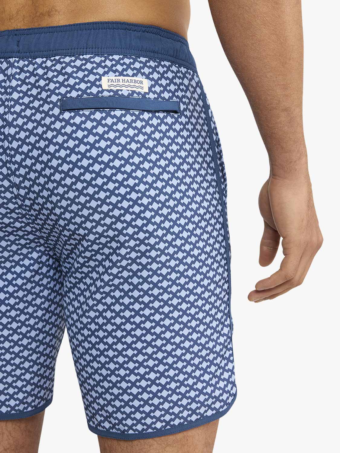 Men's swim trunk with blue and white geometric anchor pattern and navy waistband.