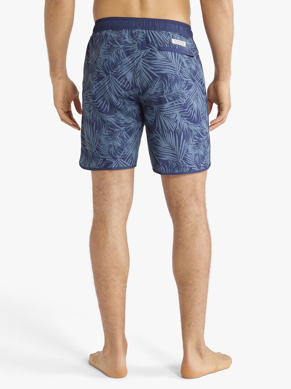 Men's swim shorts in navy blue with an all-over leafy floral pattern displayed from the back view.