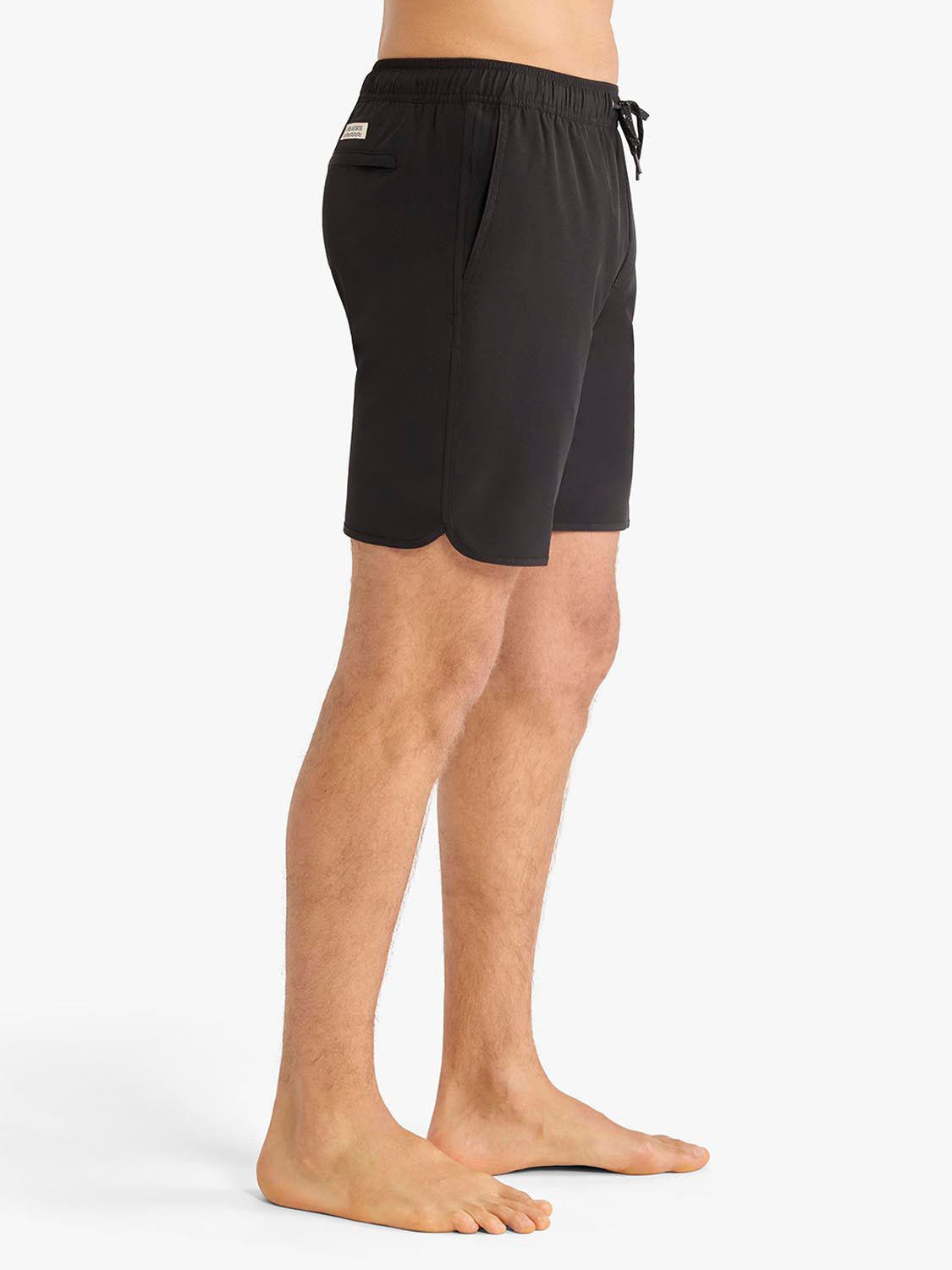 Man wearing black swim trunks with drawstring waist and side pocket detail.