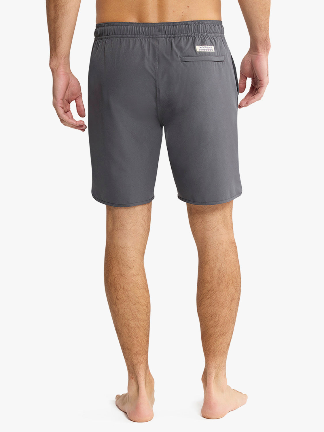 Man wearing slate gray shorts with elastic waistband and back pocket patch label.