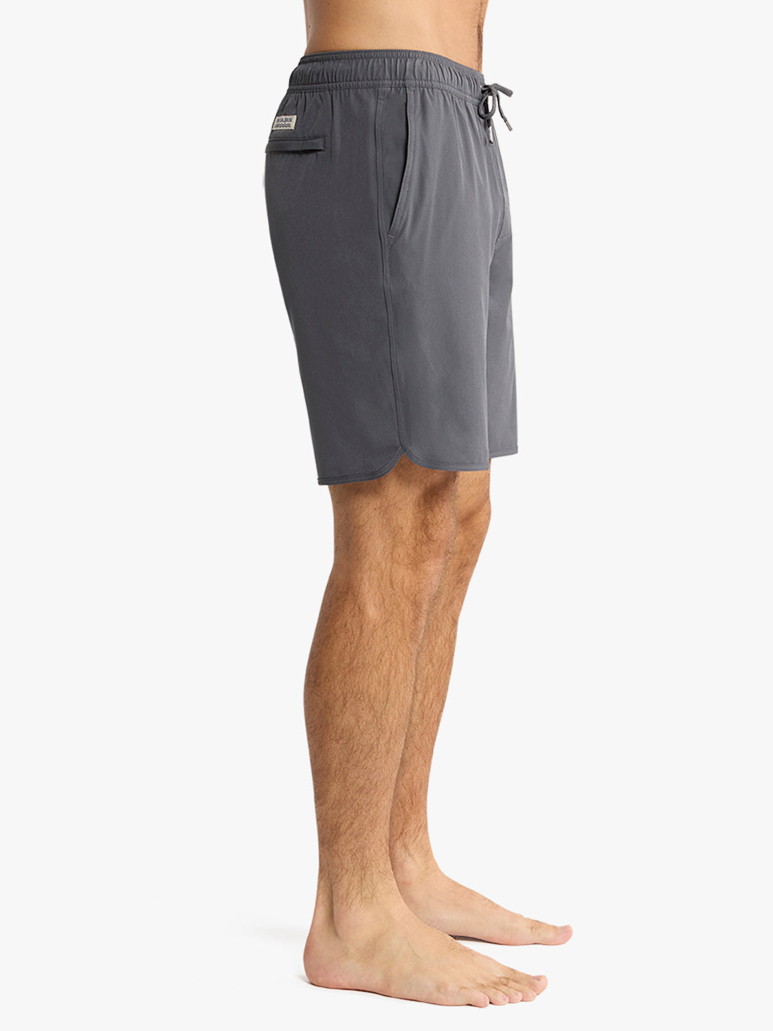 Man wearing slate gray swim trunks with drawstring waist and side pocket detail.