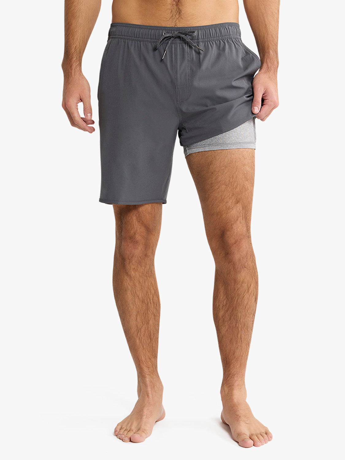 Man wearing slate gray swim trunk with gray mesh lining and drawstring waist.