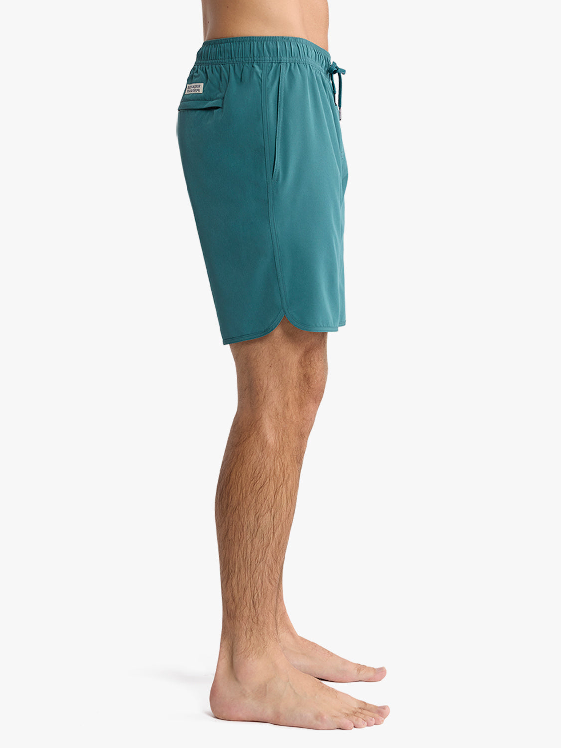 Man wearing teal-green swim shorts with elastic waistband and side pocket detail.