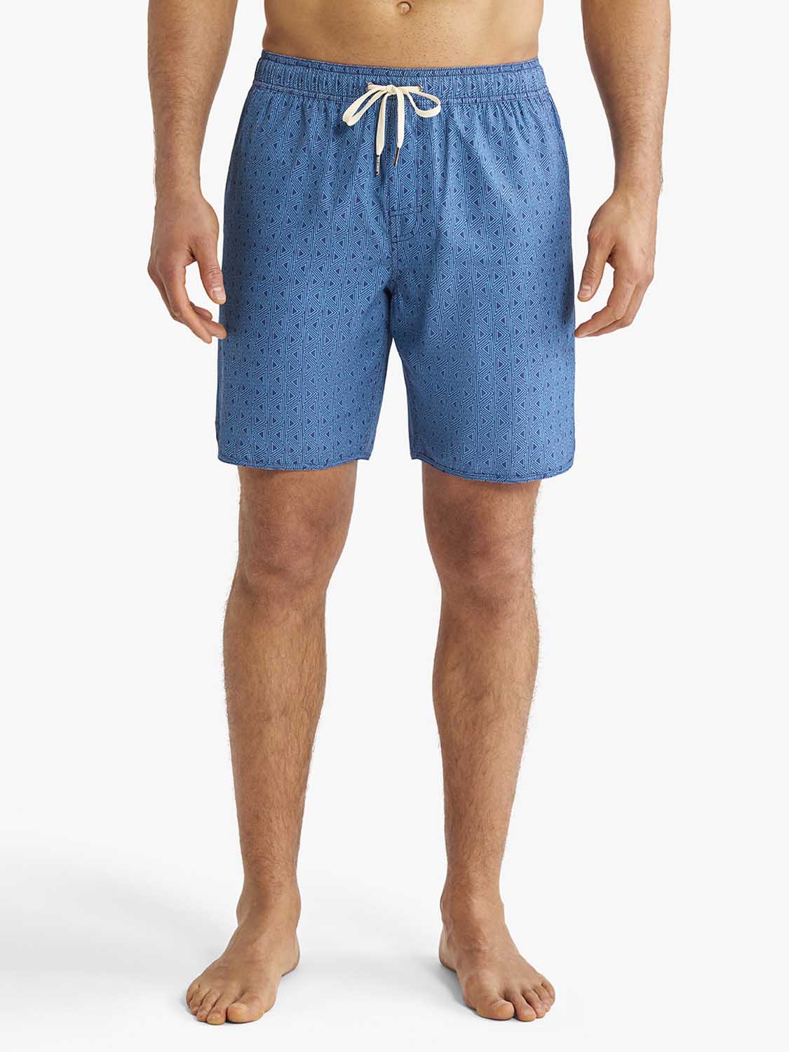 Man wearing electric blue geometric patterned swim trunks with a drawstring waist.