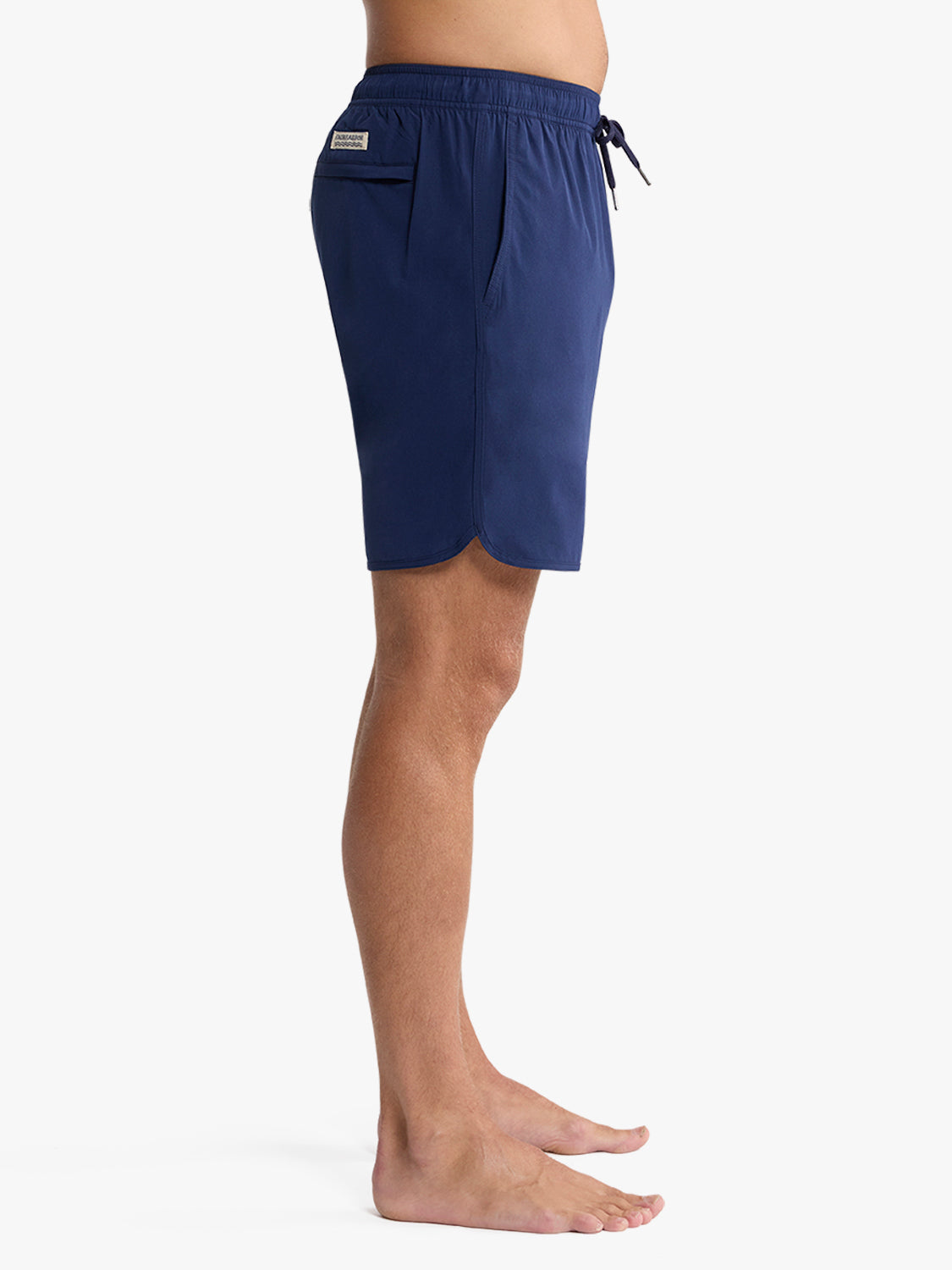 Navy blue swim trunks with drawstring waistband and side pocket displayed on model.