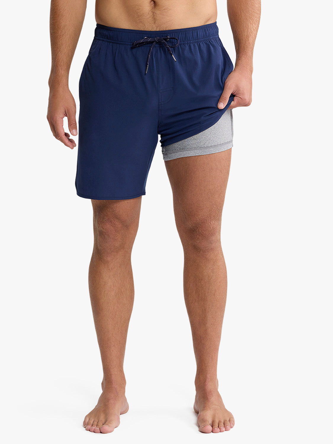 Man wearing navy swim trunks with gray inner shorts and drawstring waistband.