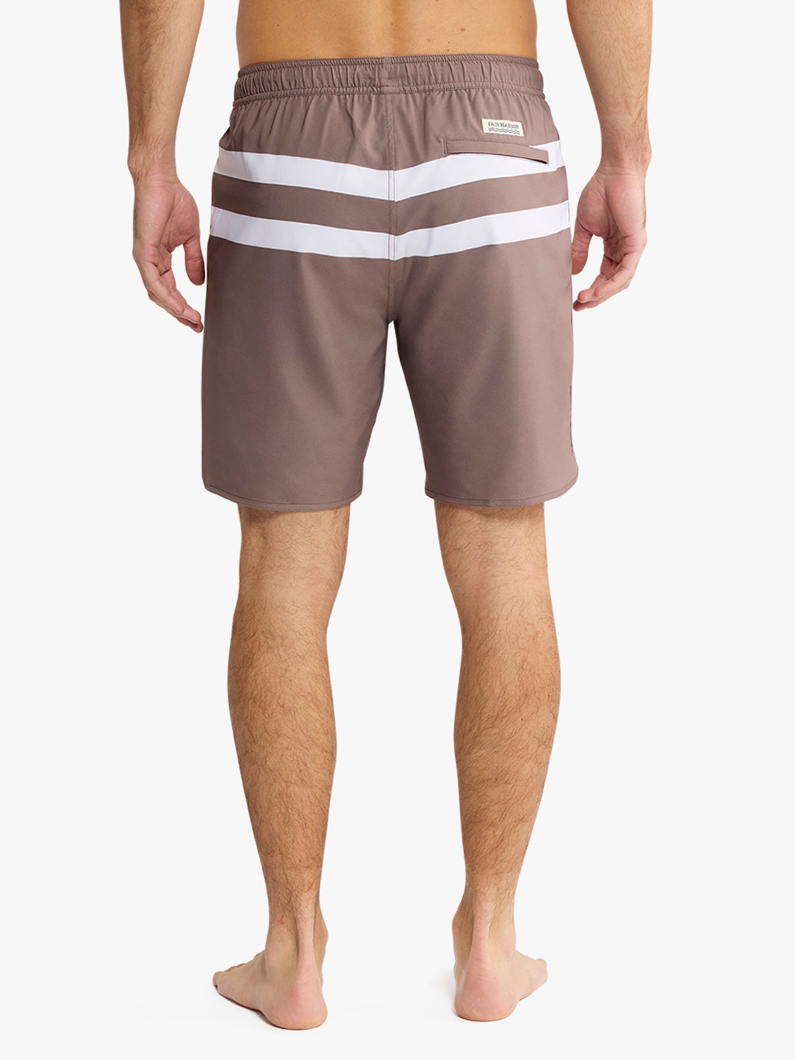 Man wearing brown swim trunks with white horizontal stripes and elastic waistband.