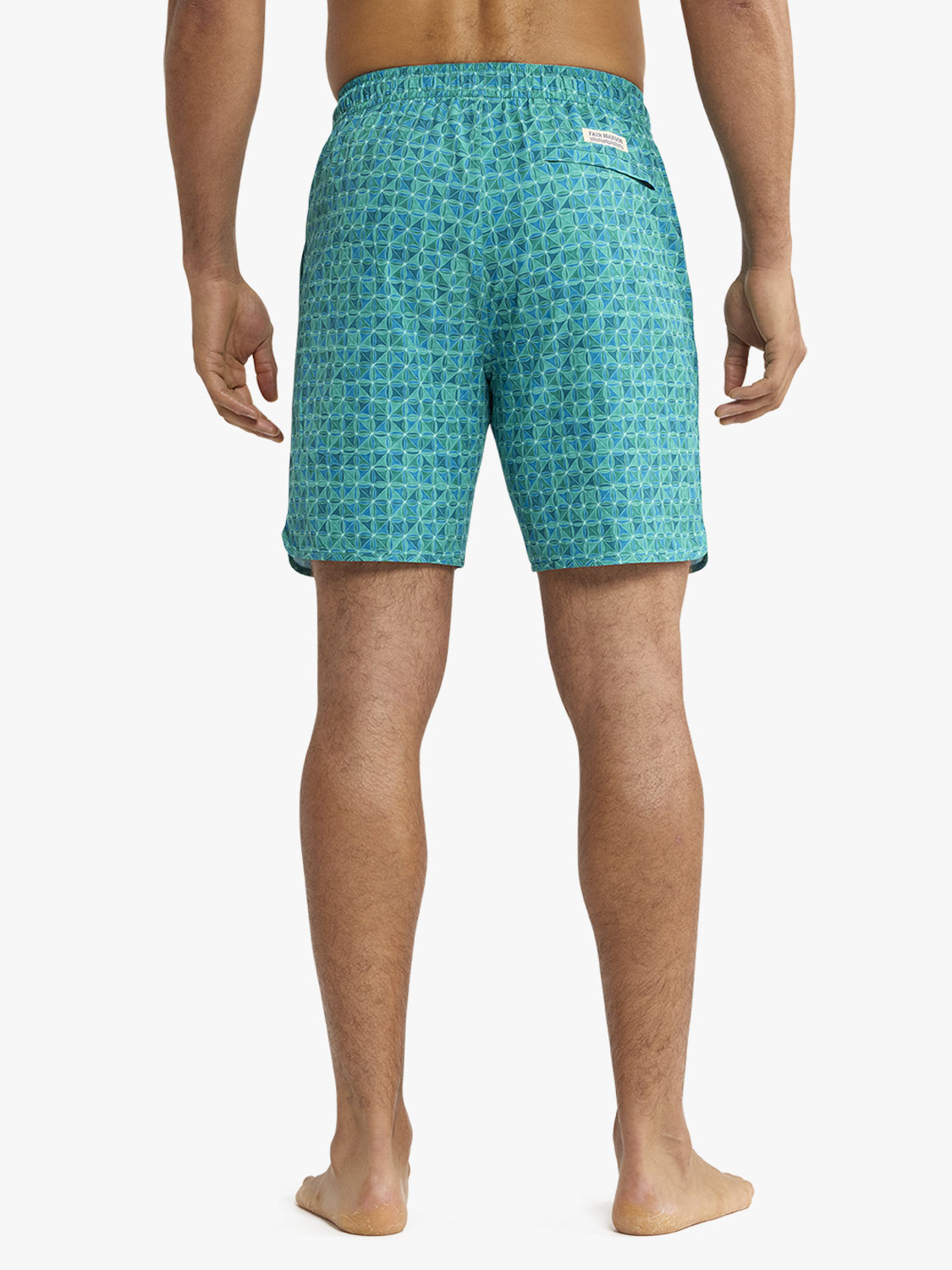 Man wearing seaglass teal swim shorts with geometric tile pattern viewed from behind.