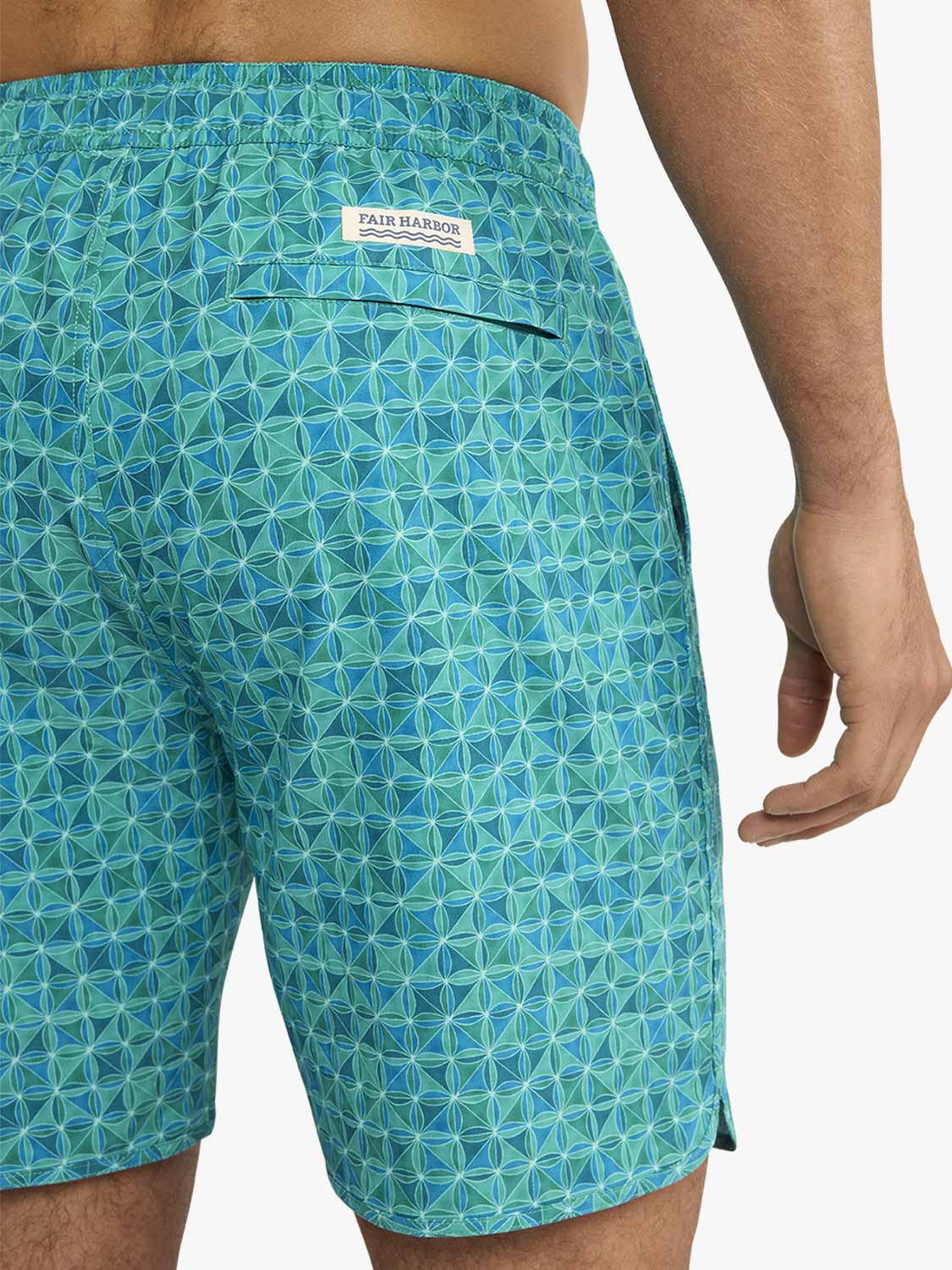 Turquoise swim trunks with geometric tile pattern and Fair Harbor brand label.