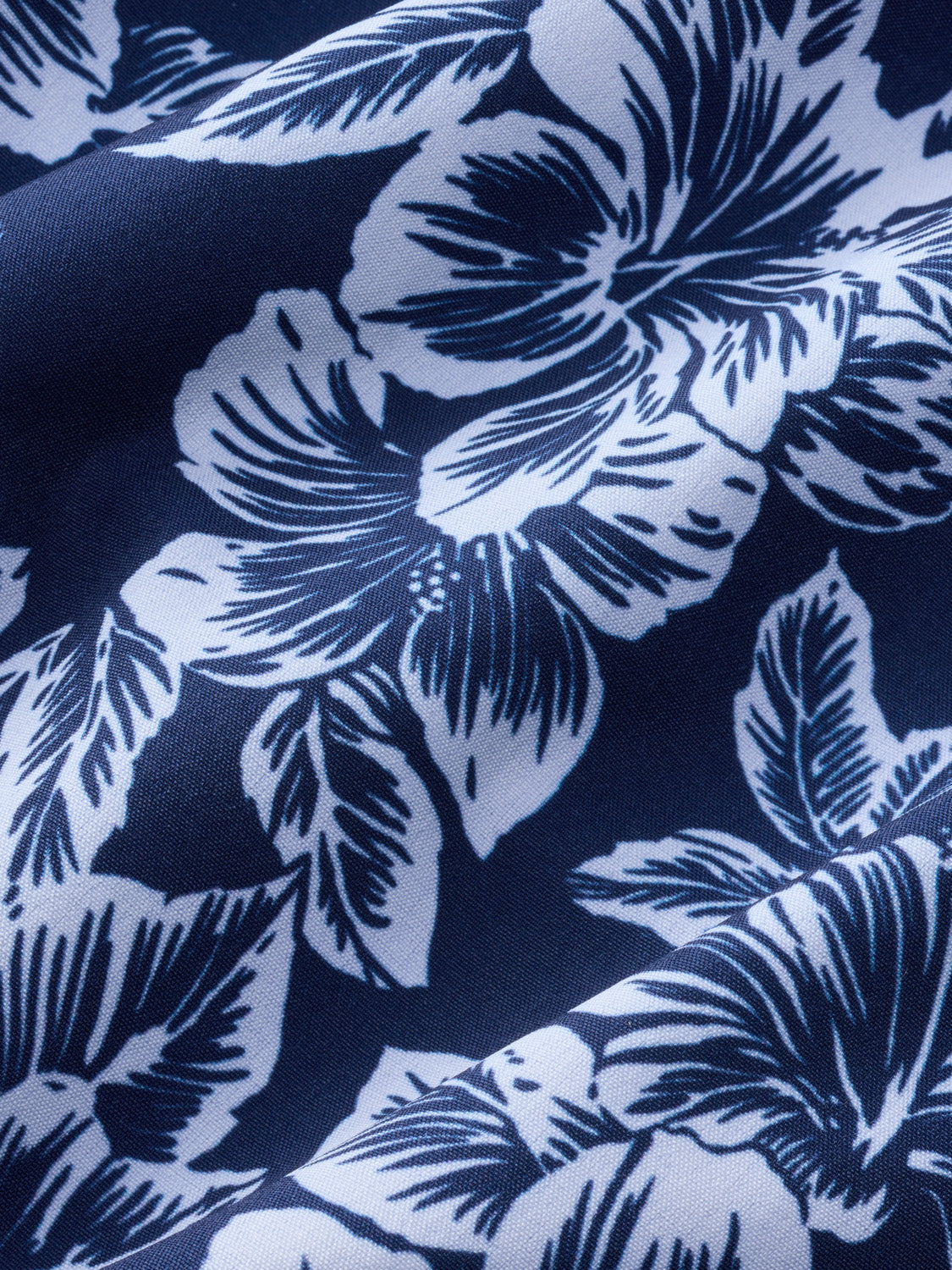 Navy trunk fabric features light blue botanical leaf print pattern on dark navy background.