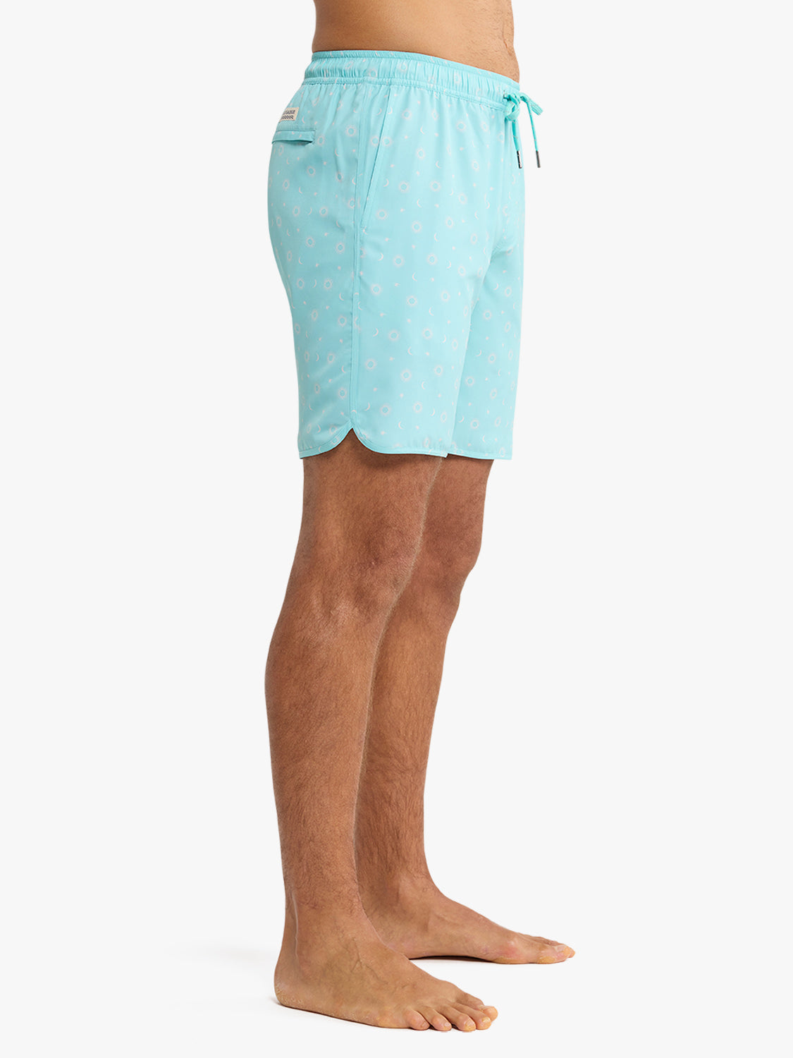Turquoise swim trunks with white sun and star patterns throughout and drawstring waist.