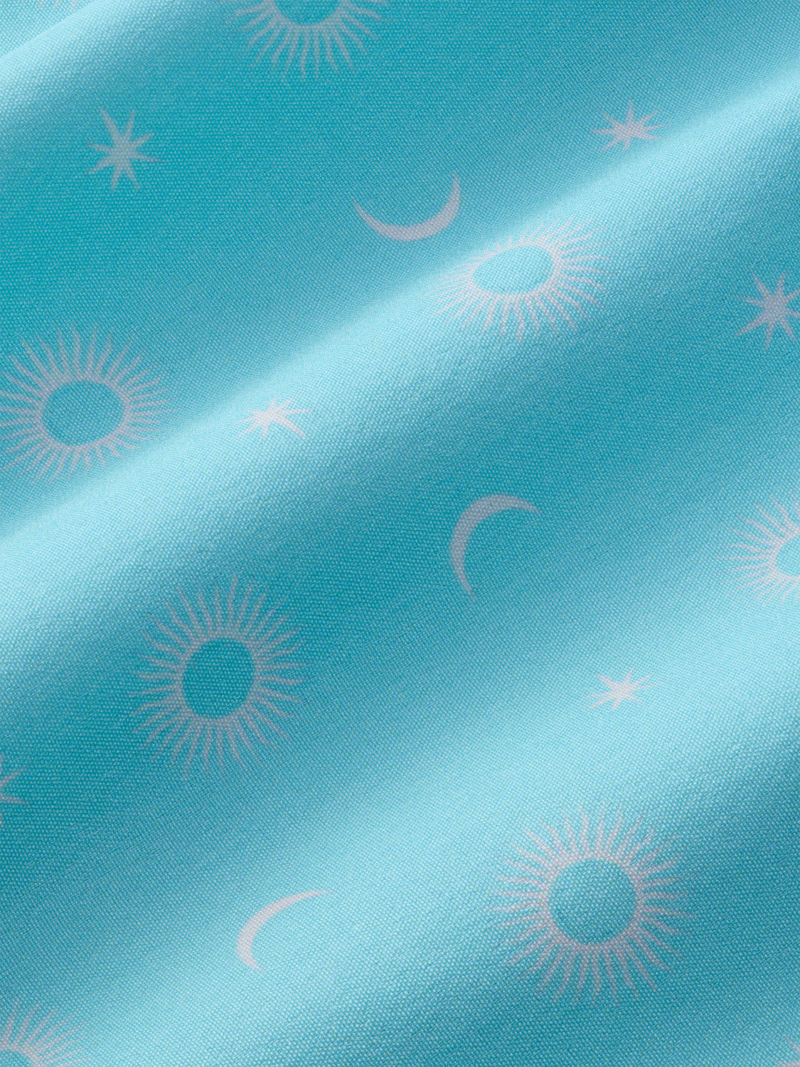 Turquoise fabric with gray sun and crescent moon pattern displayed at an angle.