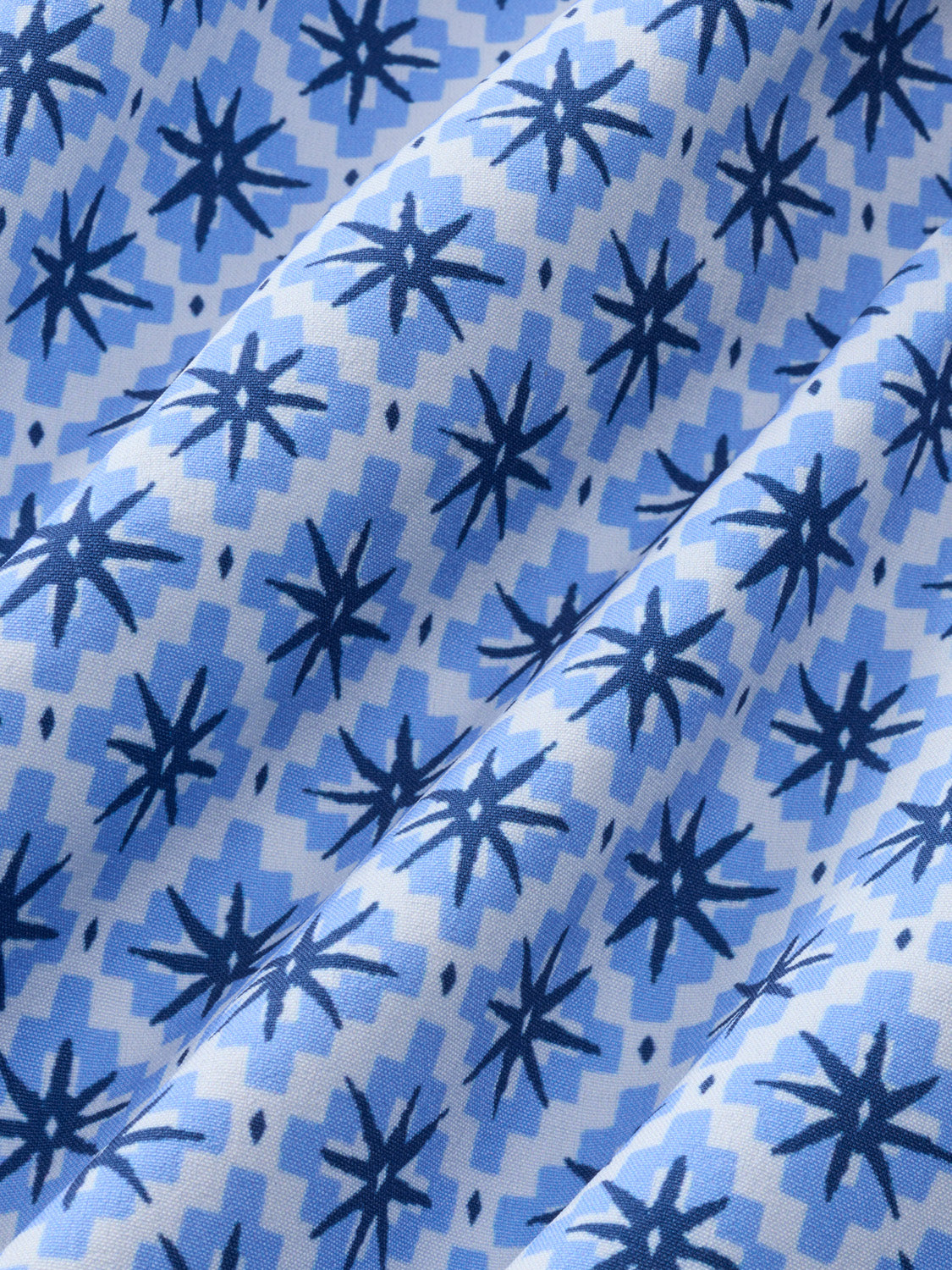 Folded blue fabric with dark navy star and checkered mosaic pattern throughout.