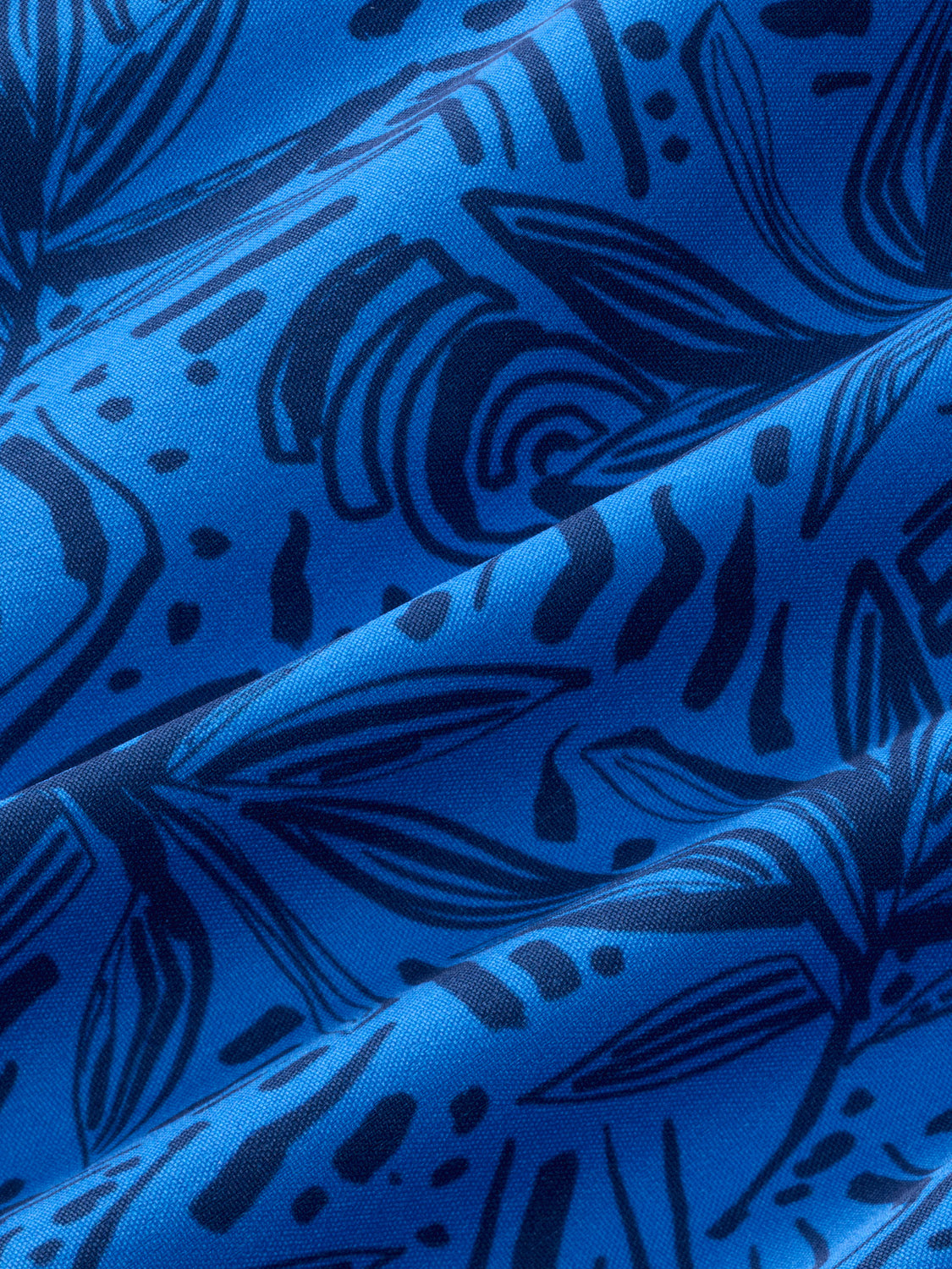 Bright blue fabric with dark blue painted leaf and botanical line patterns displayed at an angle.