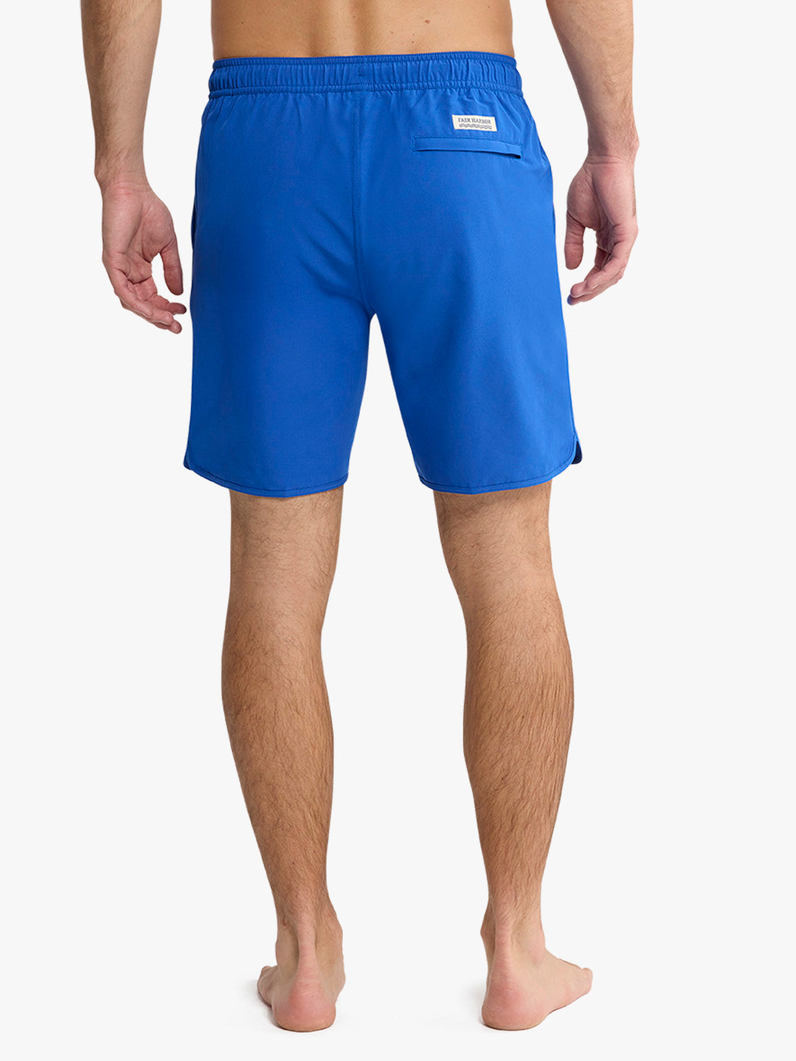 Man wearing cobalt blue swim shorts with elastic waistband and back pocket viewed from behind.