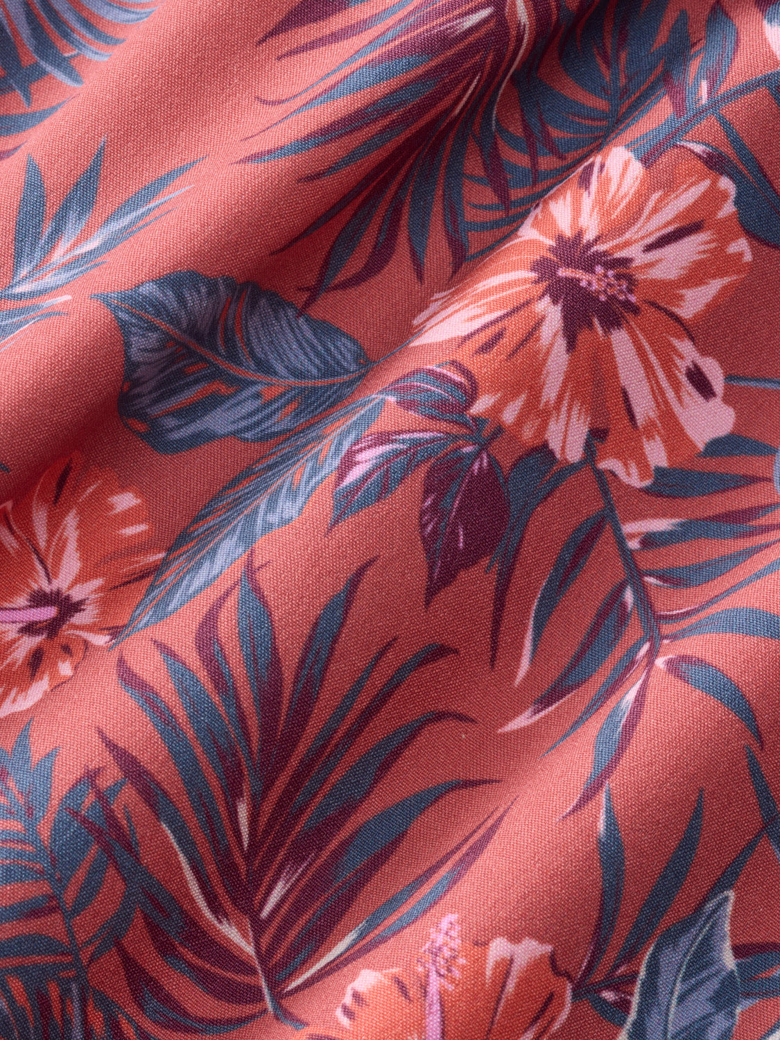 Red fabric with dark blue and navy floral and leaf print pattern throughout.