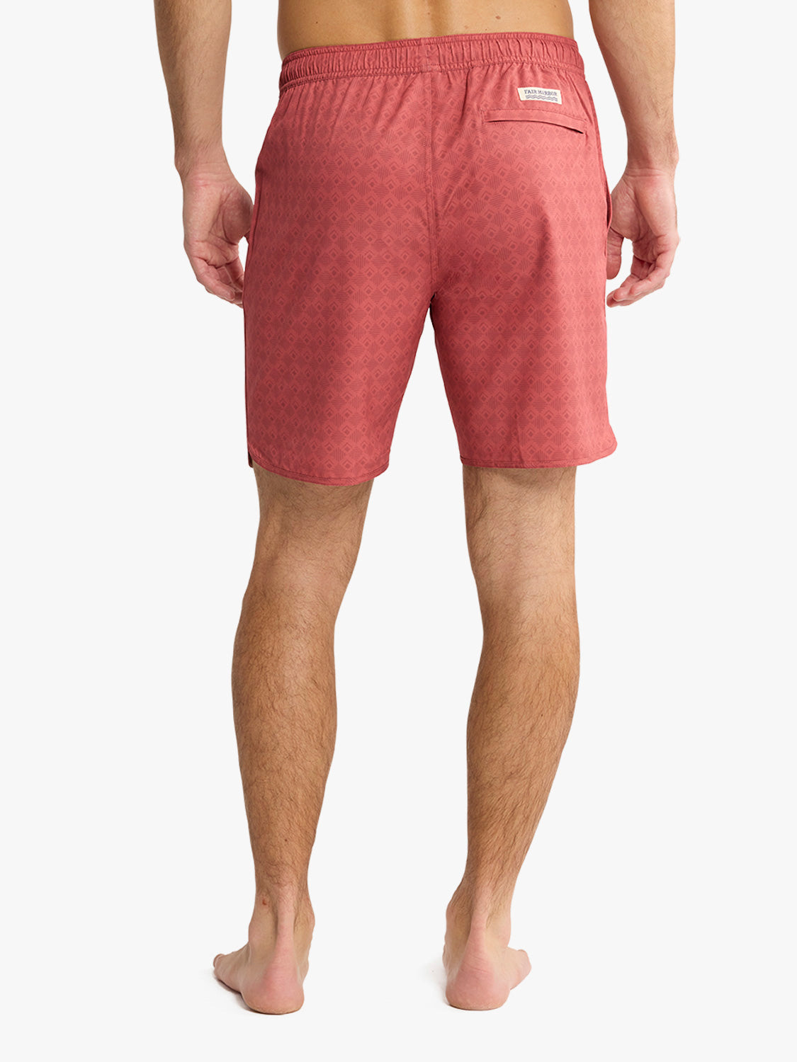 Man wearing red swim trunk with textured pattern, viewed from behind.