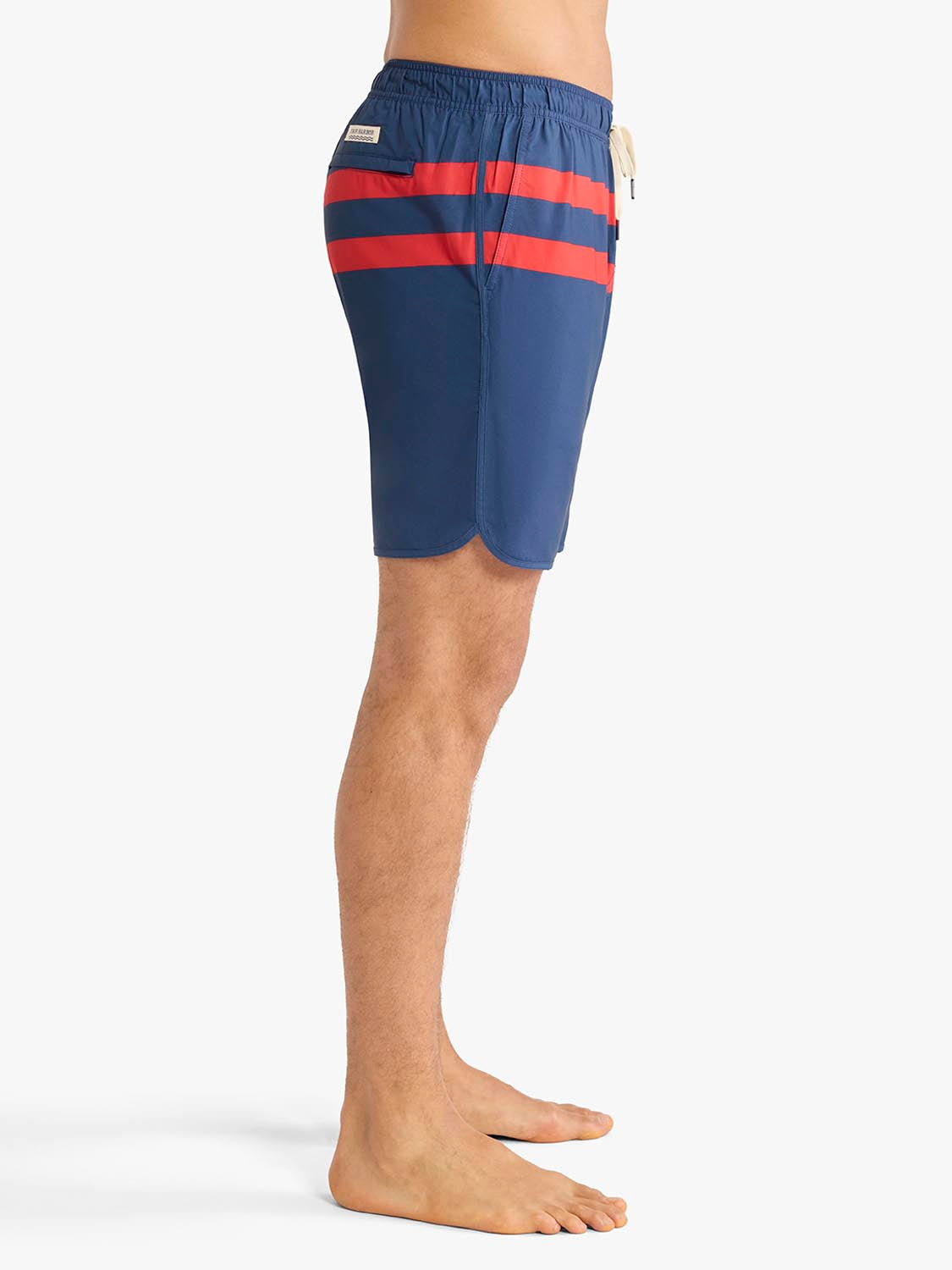 Navy swim trunk with horizontal red stripes across the thighs and a small patch detail.
