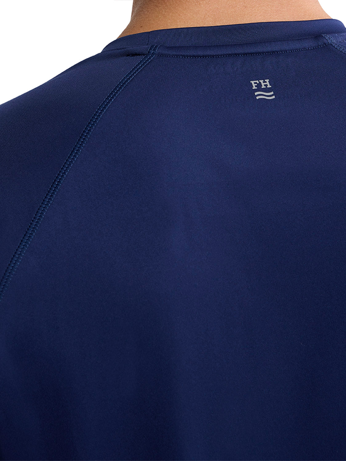 Back view of a navy blue rashguard with an anchor logo and FH initials embroidered on the shoulder.