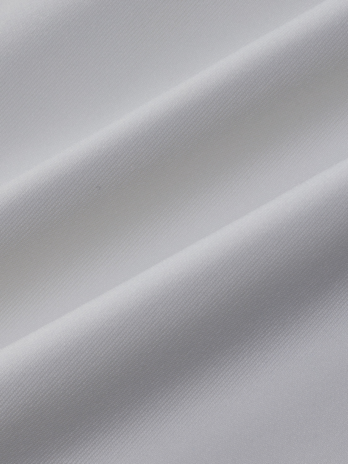 White rashguard with textured fabric showing diagonal folds and draping details.