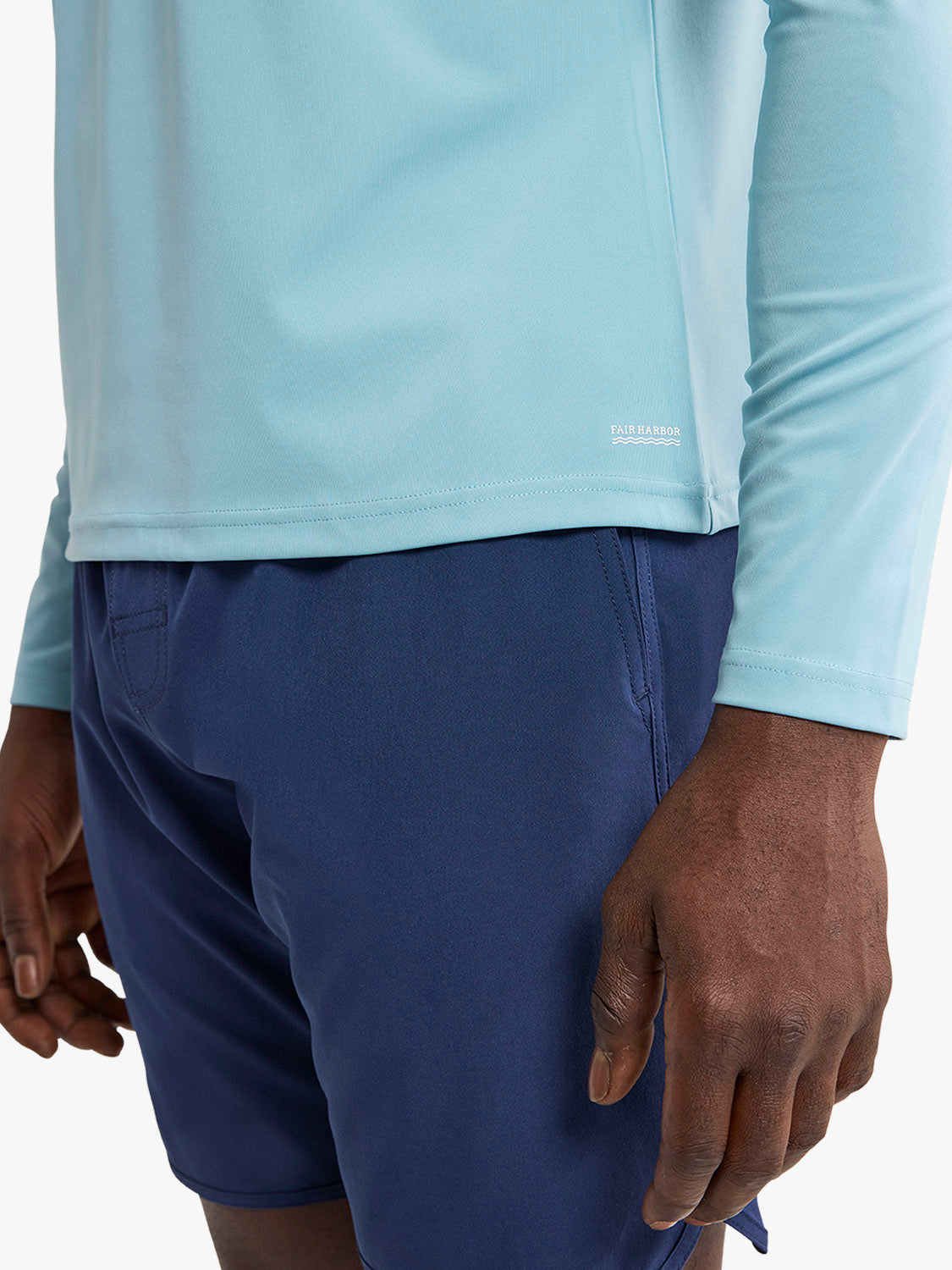 Bay blue long-sleeve rashguard with white contrast panel worn over dark navy swim shorts.