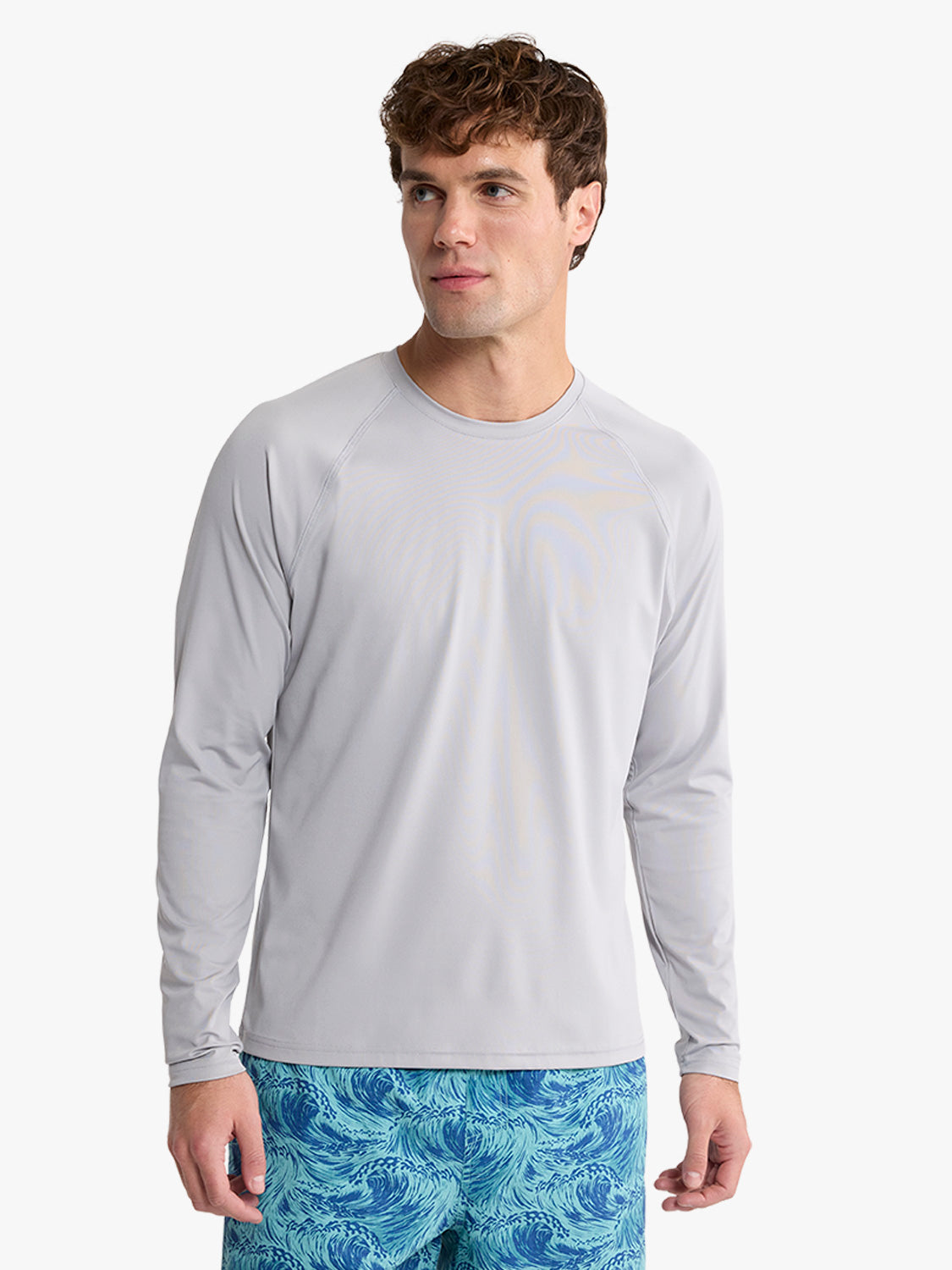 Man wearing a gray long-sleeved rashguard with an anchor graphic on the chest.