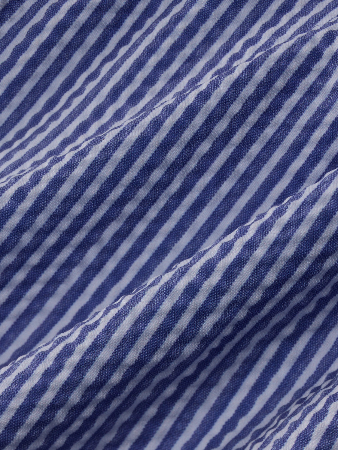 Light blue and white seersucker fabric with diagonal striped texture pattern throughout.