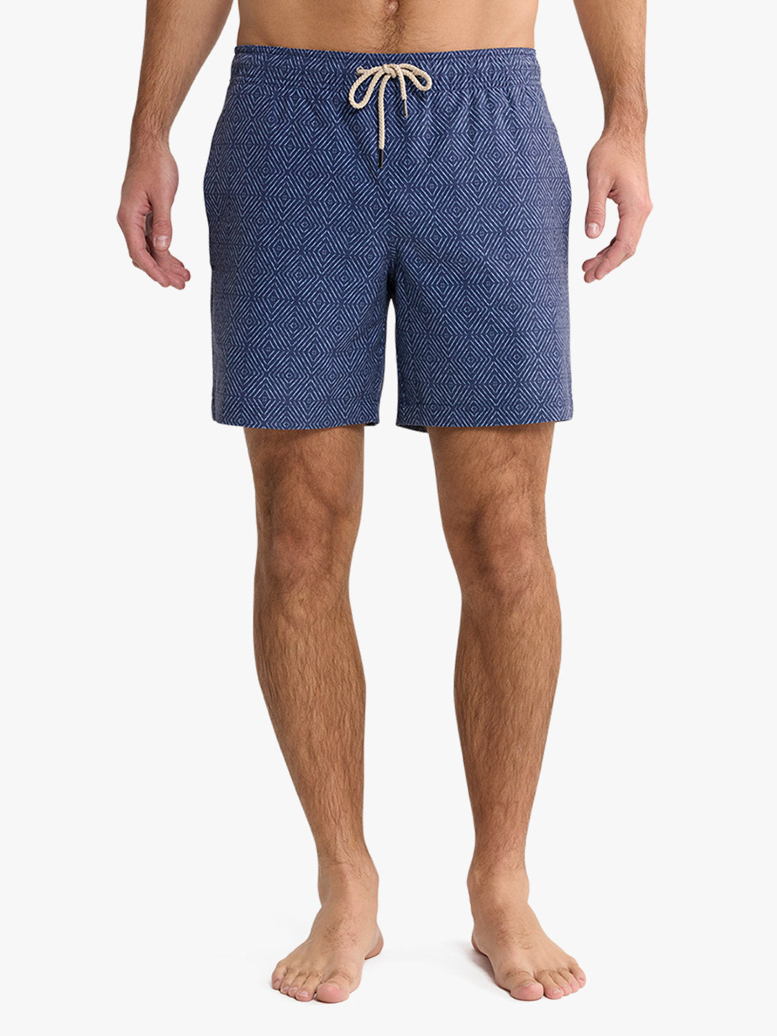 Man wearing navy shibori-patterned swim trunk with cream drawstring, shown from waist down.
