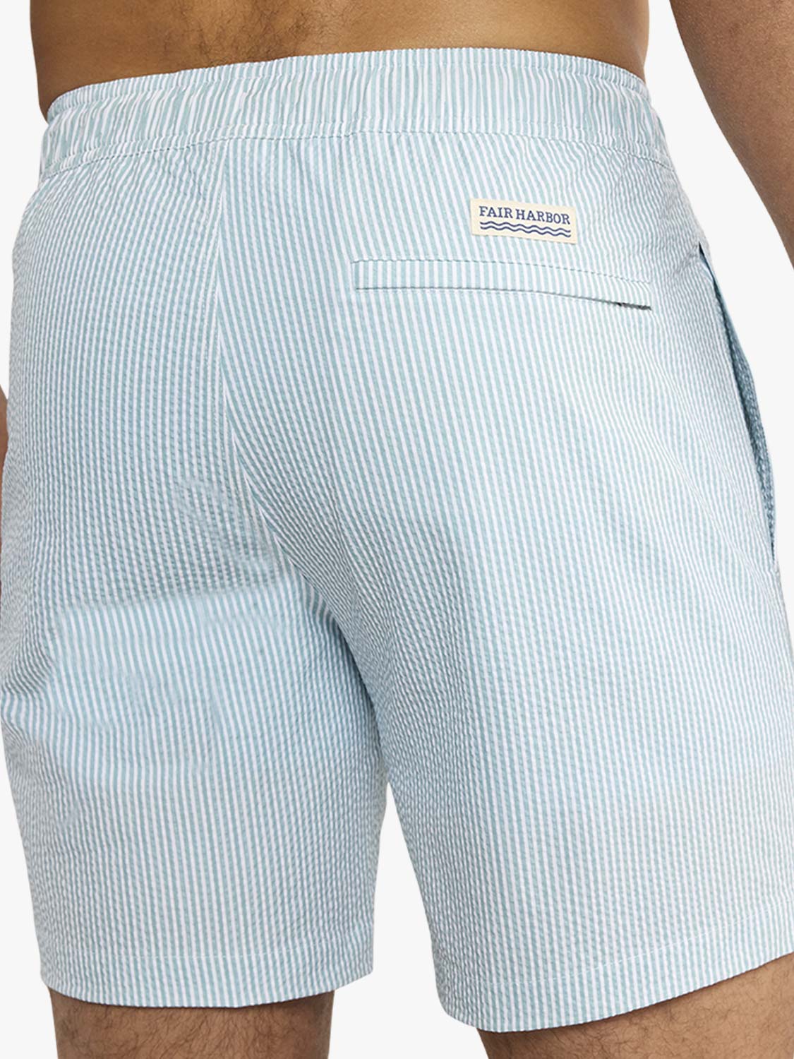Light blue and white striped seersucker swim trunk with Fair Harbor branding on back pocket.