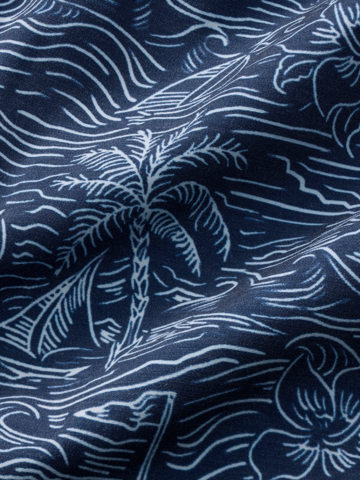 Navy blue fabric with white palm tree and wave pattern