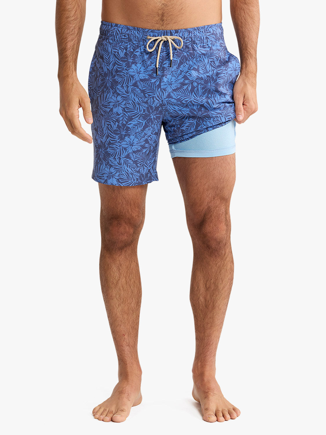 Men's swim trunks featuring a blue leafy pattern with light blue liner shorts and drawstring waistband.