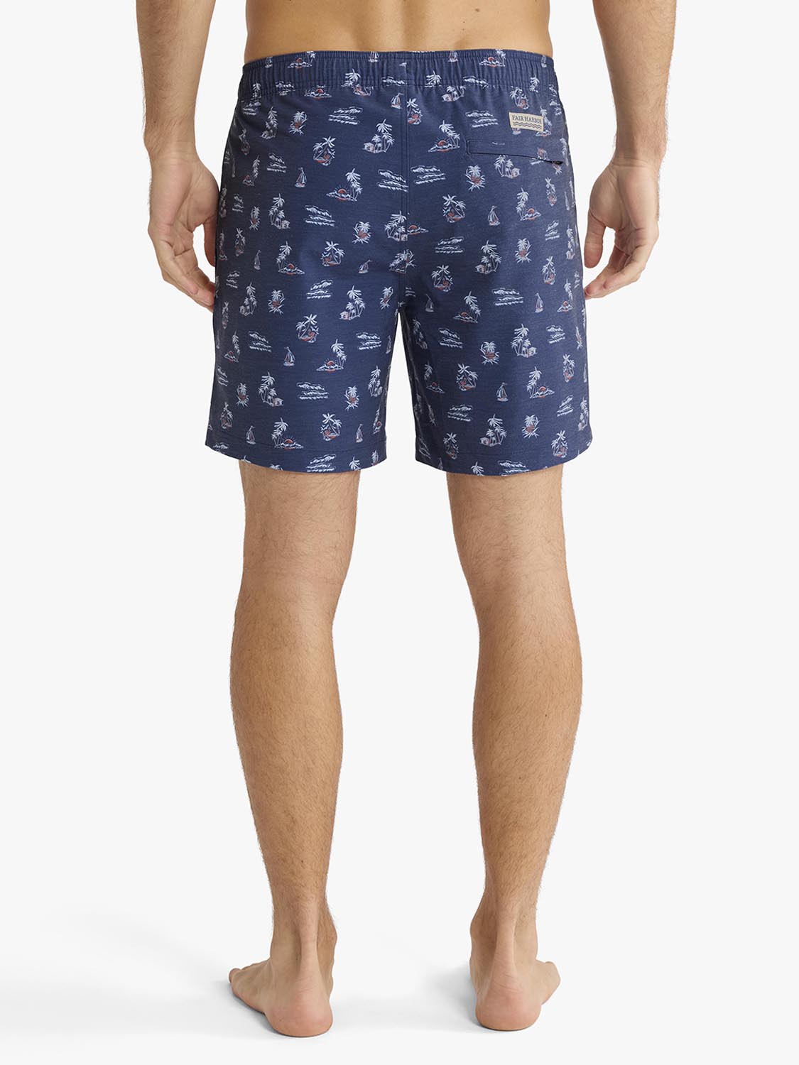 Navy swim trunk with white nautical and tropical print throughout, shown from behind on male model.