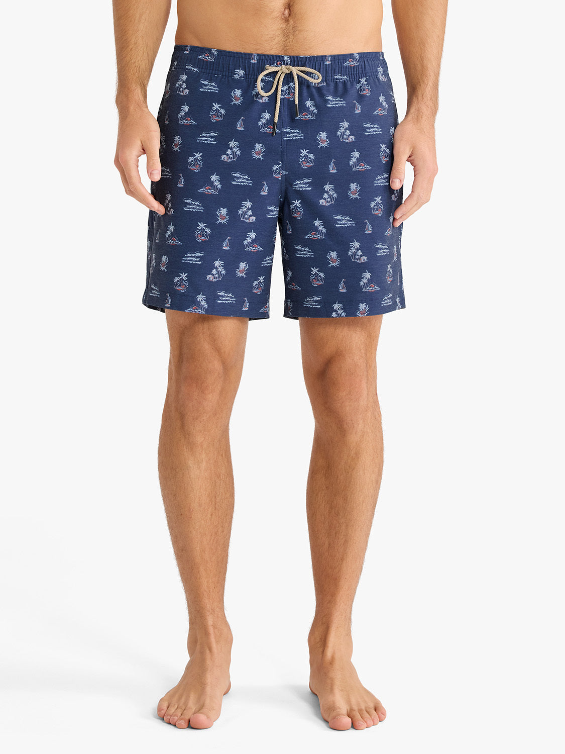 Navy swim trunks with white tropical and nautical print pattern and tan drawstring.