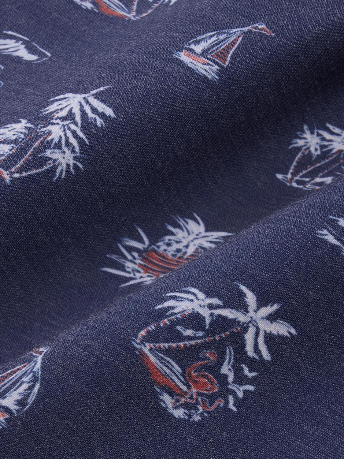 Navy fabric with repeating pattern of white and red sailboats and palm trees throughout.