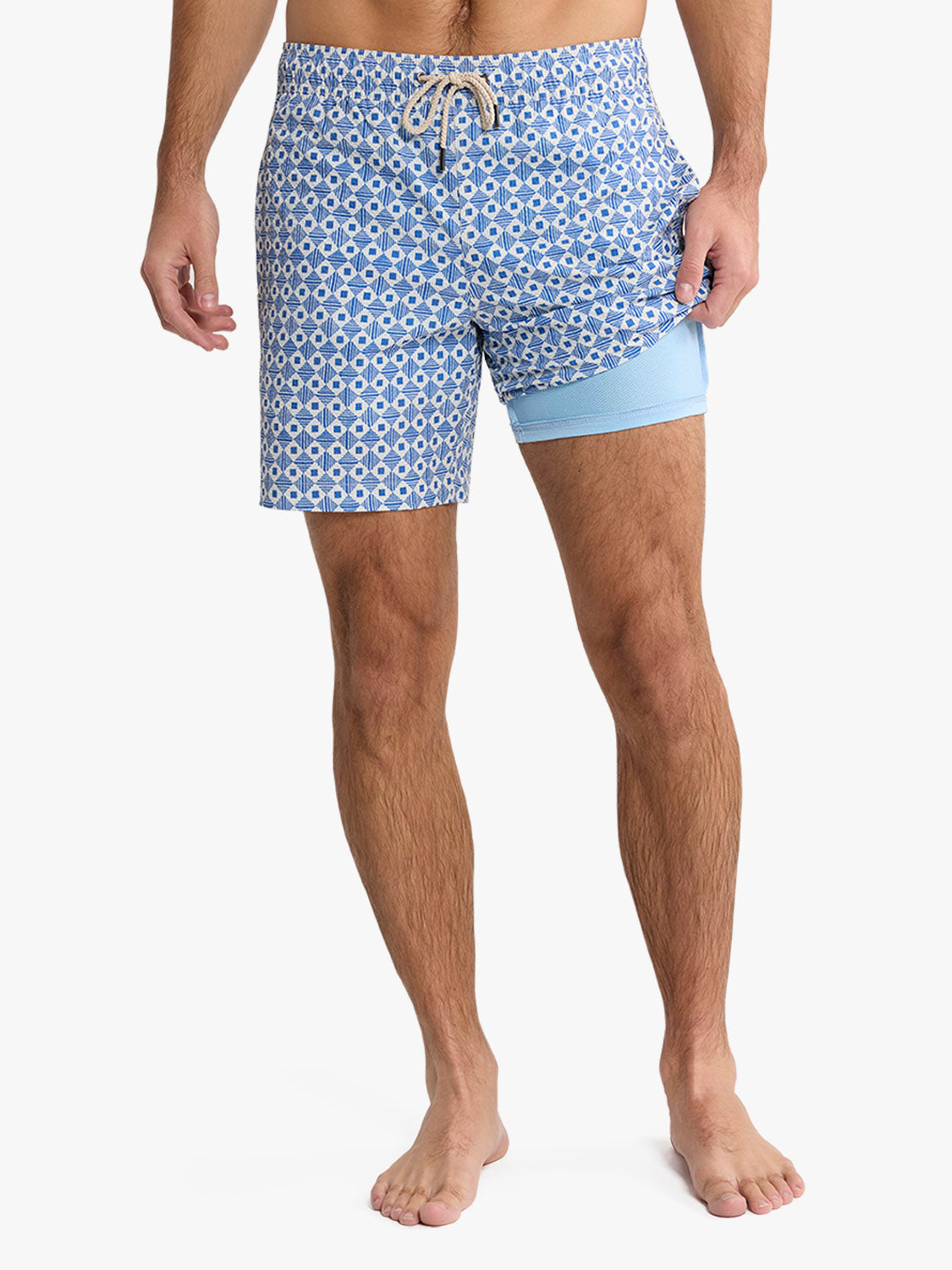 Men's swim trunks with blue geometric tile pattern and light blue liner shorts.