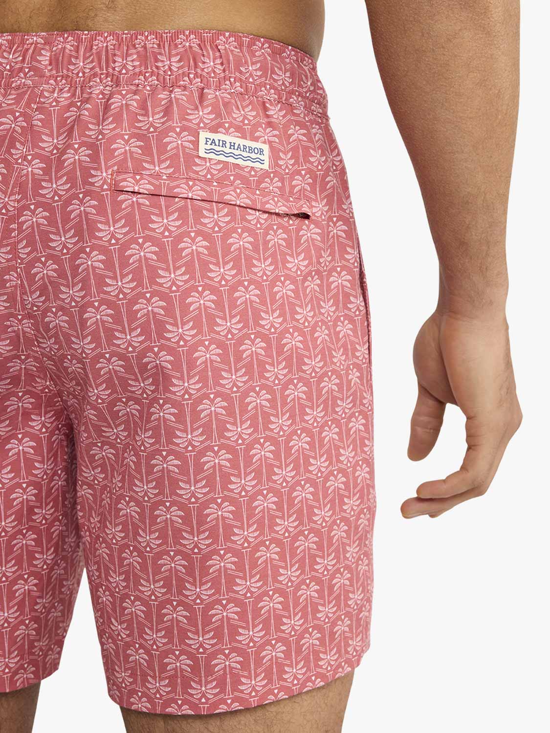 Red swim trunks with white palm tree pattern and Fair Harbor brand label visible.