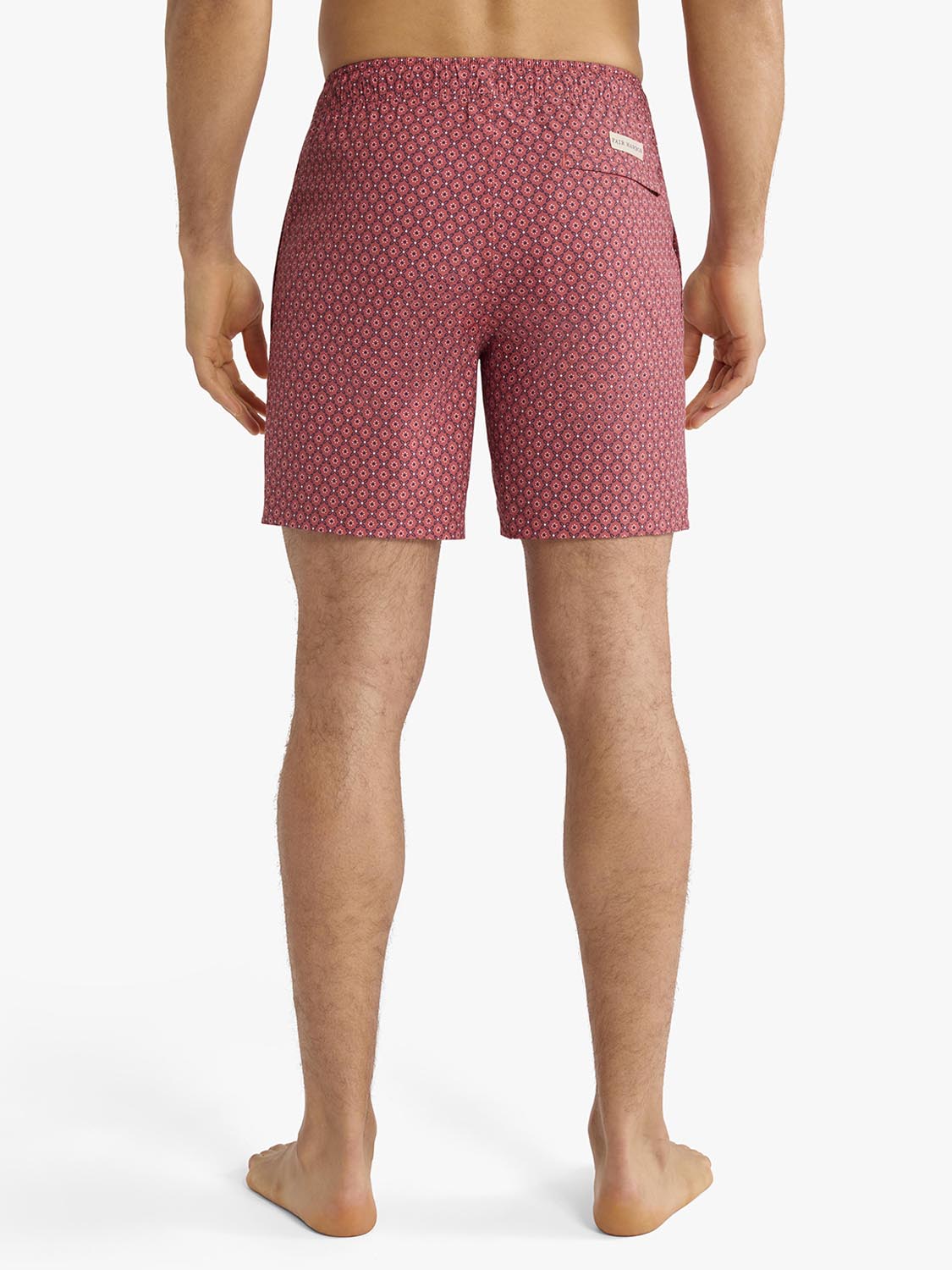 Red bandana geometric print swim trunk displayed on man from waist down showing back view.