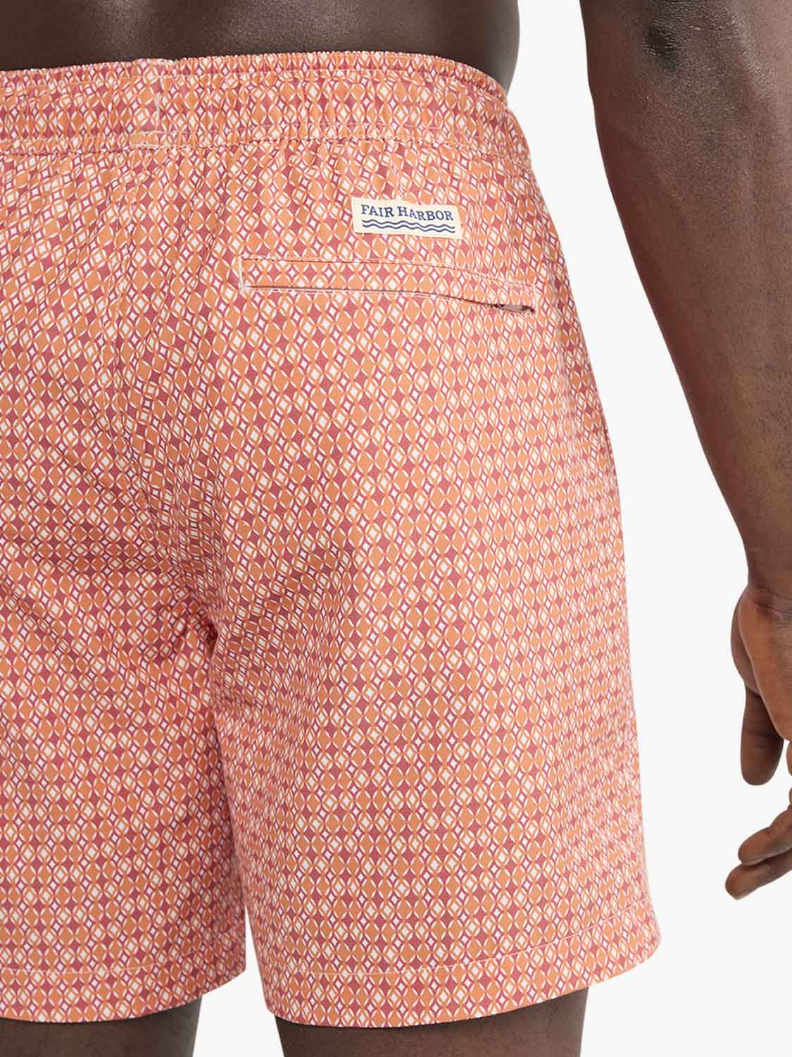 Tangerine swim trunk with geometric diamond pattern and Fair Harbor brand label on back pocket.