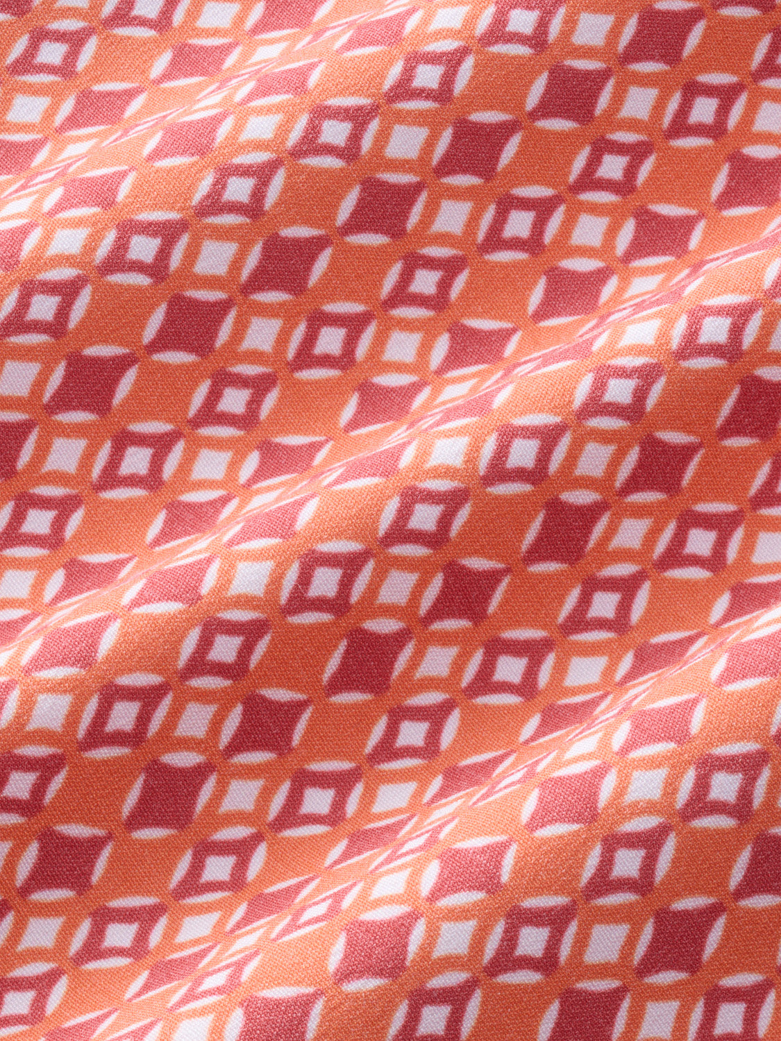 Tangerine fabric featuring a geometric diamond pattern in red, pink, and white colors.