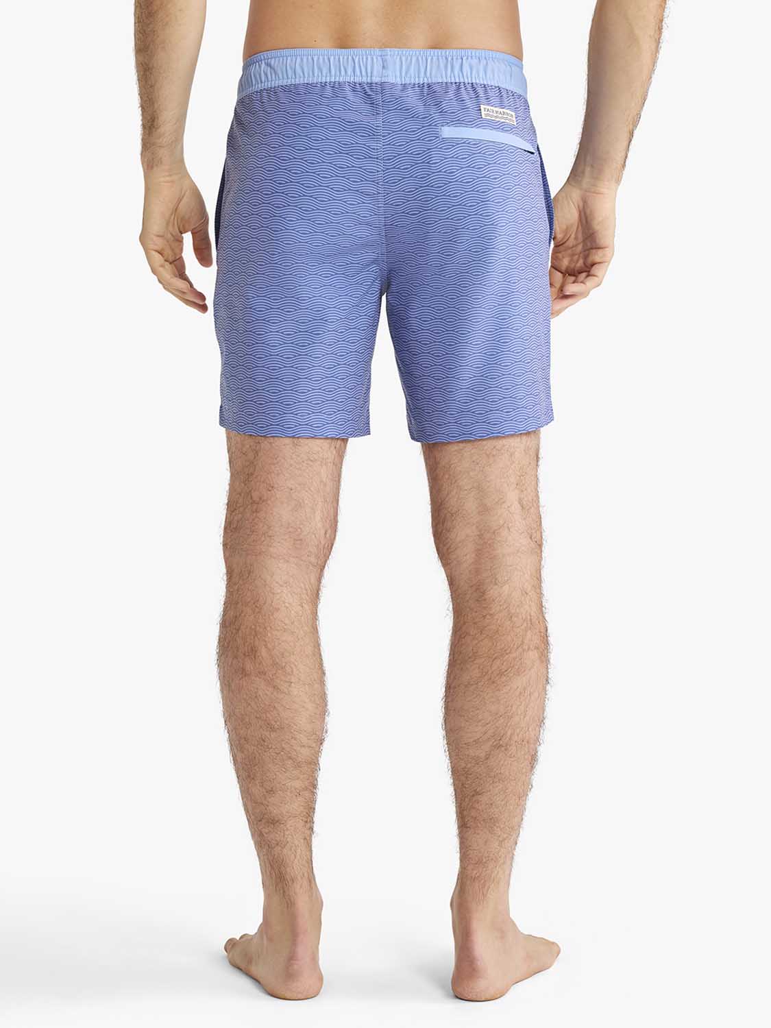 Man wearing blue swim trunks with horizontal wave pattern and light blue waistband.