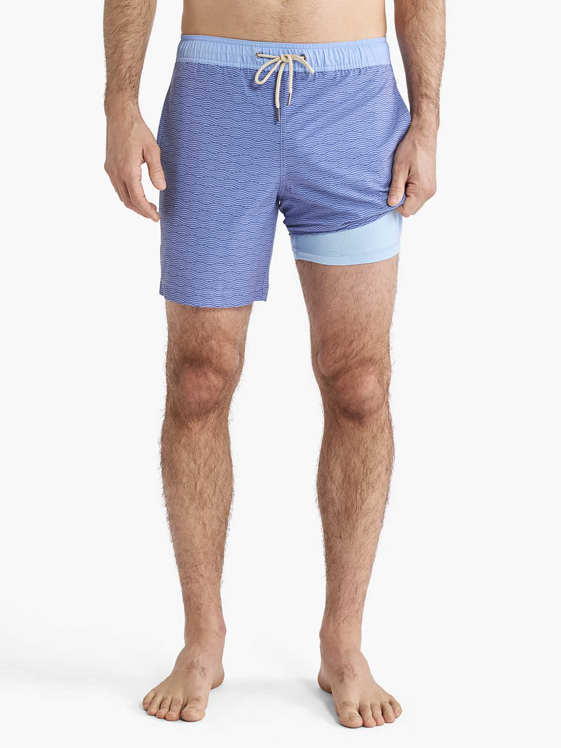 Men's blue swim trunks with wave texture pattern and light blue contrast leg cuff detail.