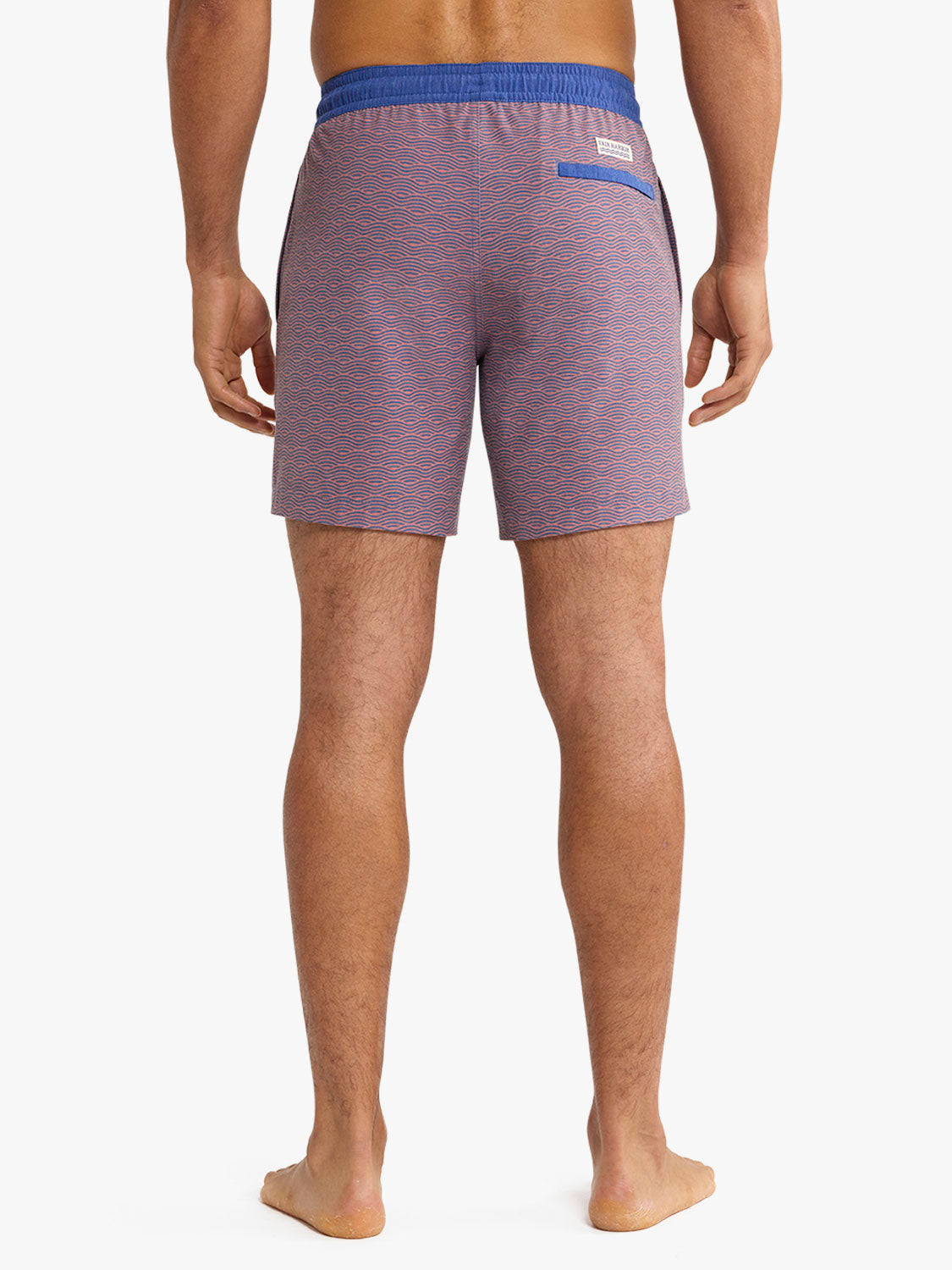 Man wearing red and blue wave-patterned swim trunks with blue waistband shown from behind.