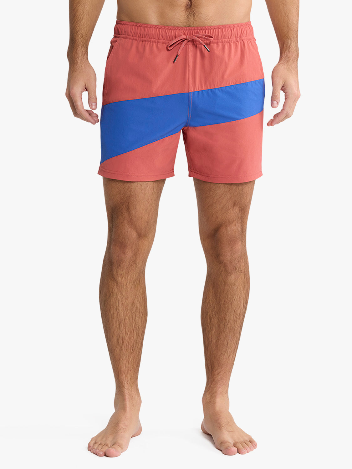 Man wearing red and blue colorblock swim trunks with diagonal stripe pattern and drawstring waist.