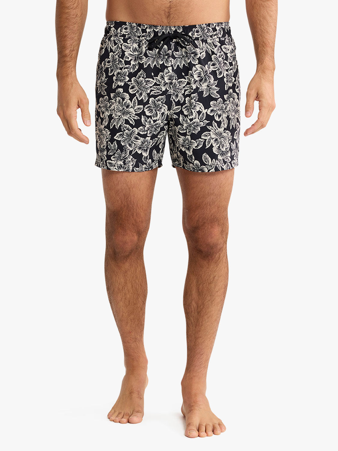 Men's black swim shorts with white hibiscus and floral print pattern throughout.