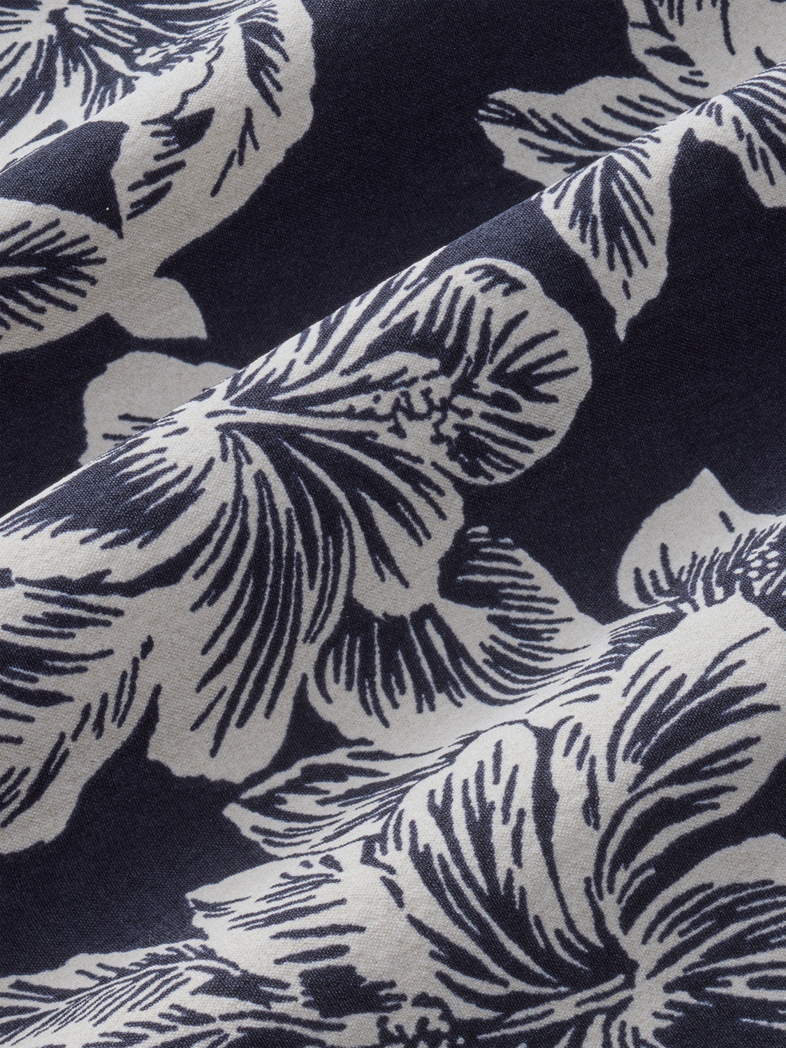 Black and white fabric with hibiscus flower petals featuring detailed line work throughout the textile design.