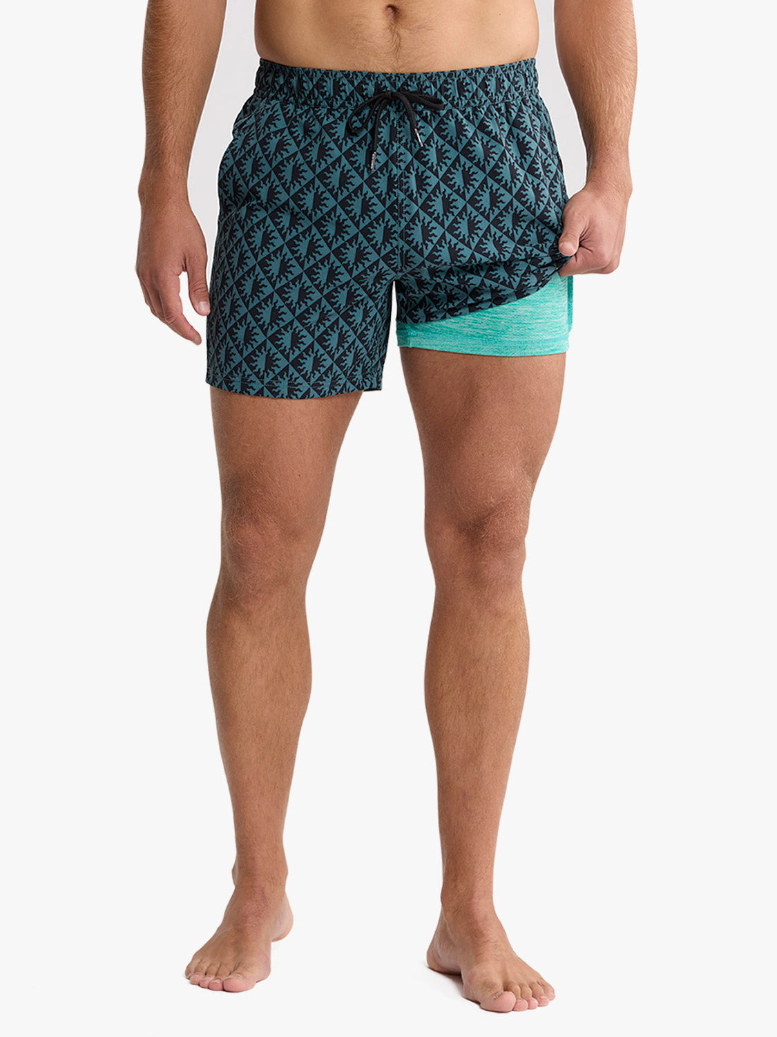 Man wearing blue patterned swim trunks with turquoise inner shorts visible on the side.