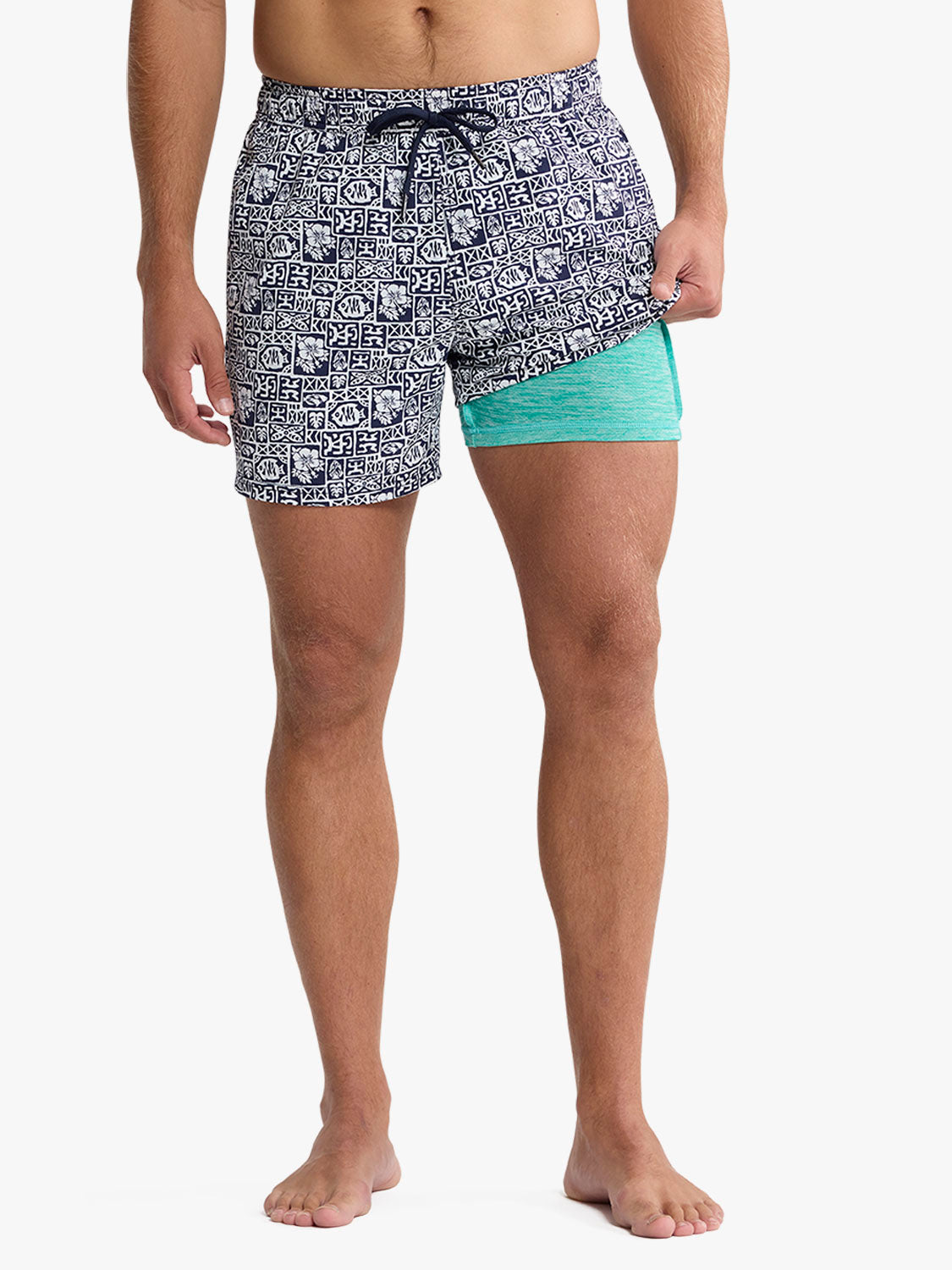 Men's swim trunks with navy geometric tile pattern and turquoise contrast panel detail.