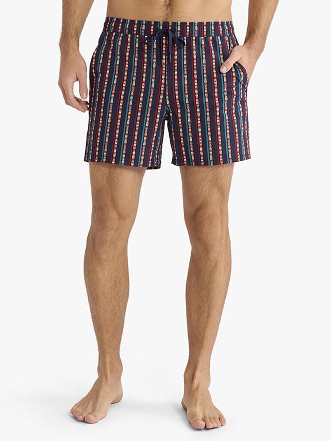 Men's navy swimming trunk with red, white, and teal vertical stripe pattern and side pockets.