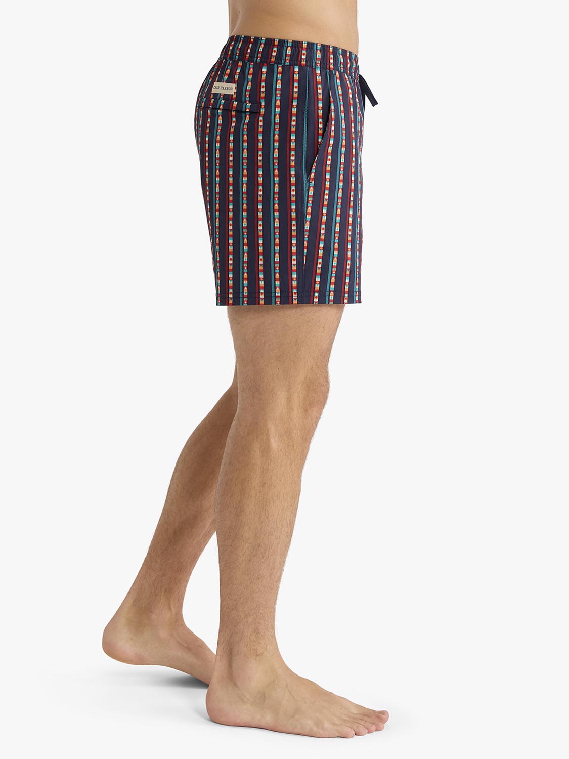 Men's swim trunk with navy background and red, white, and turquoise vertical sailing stripe pattern.