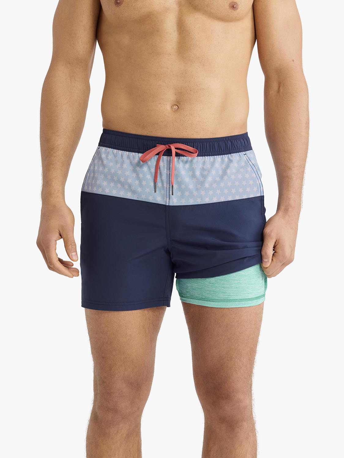 Navy swim trunks with light blue patterned waistband, mint green leg panel, and coral drawstring.